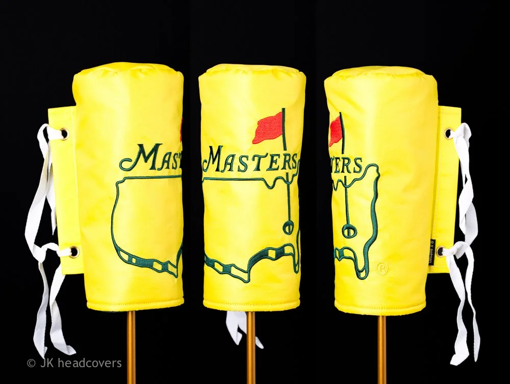 Three yellow flag-shaped objects resembling marshmallow roasting sticks, each with a map of Massachusetts and the word 'Masters' on the front, mounted on wooden sticks with white ties, set against a black background.