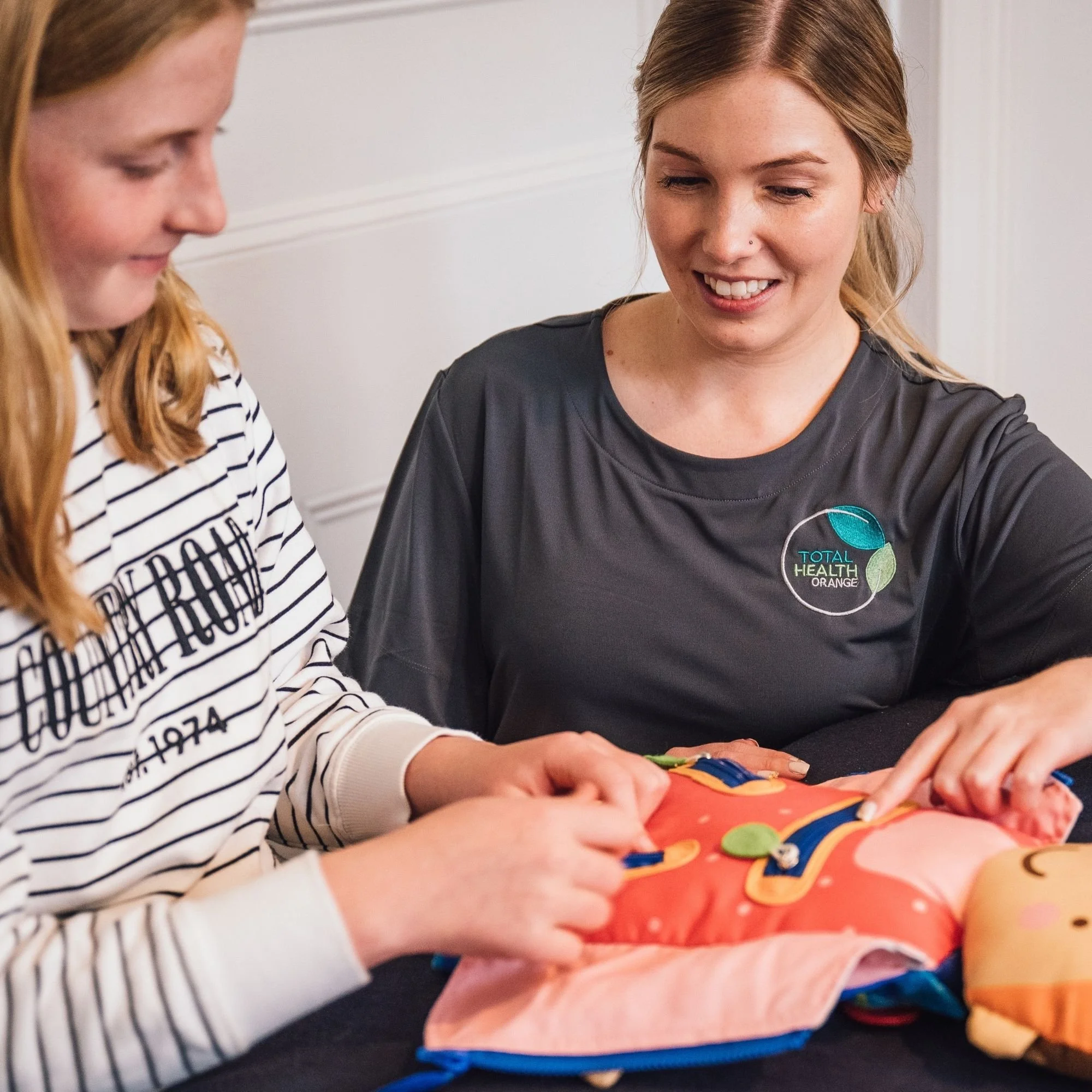 Occupational therapist supporting a child with a hands-on activity.jpg