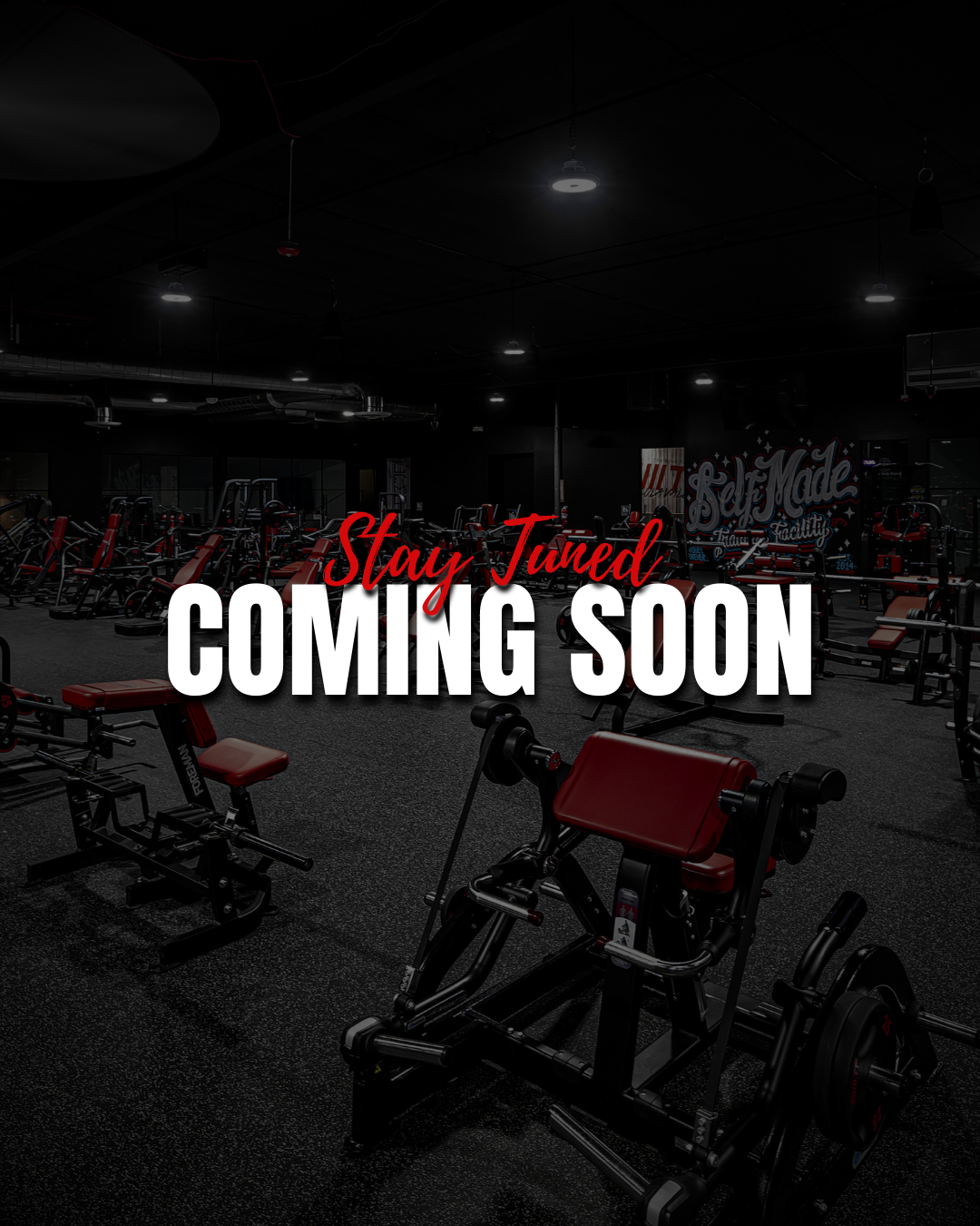 Dark gym with workout equipment and red and white Stay Tuned Coming Soon sign at Self Made Training Facility Temecula Valley—new 24/7 fitness center for strength training, personal coaching, and high-performance athletes.