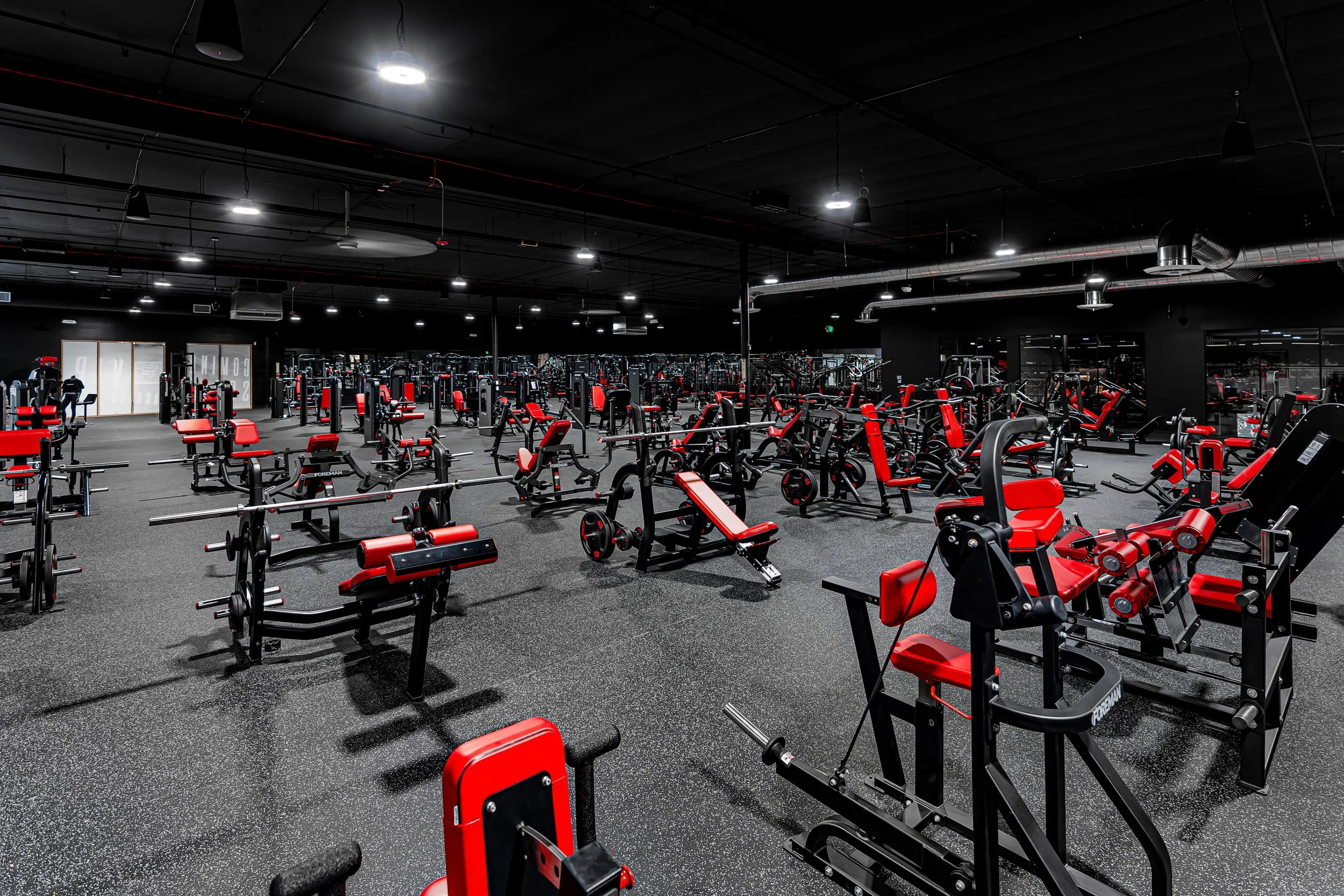 Temecula 24/7 gym with black walls, red and black equipment, and free weights at Self Made Training Facility—built for strength training and high-performance fitness.
