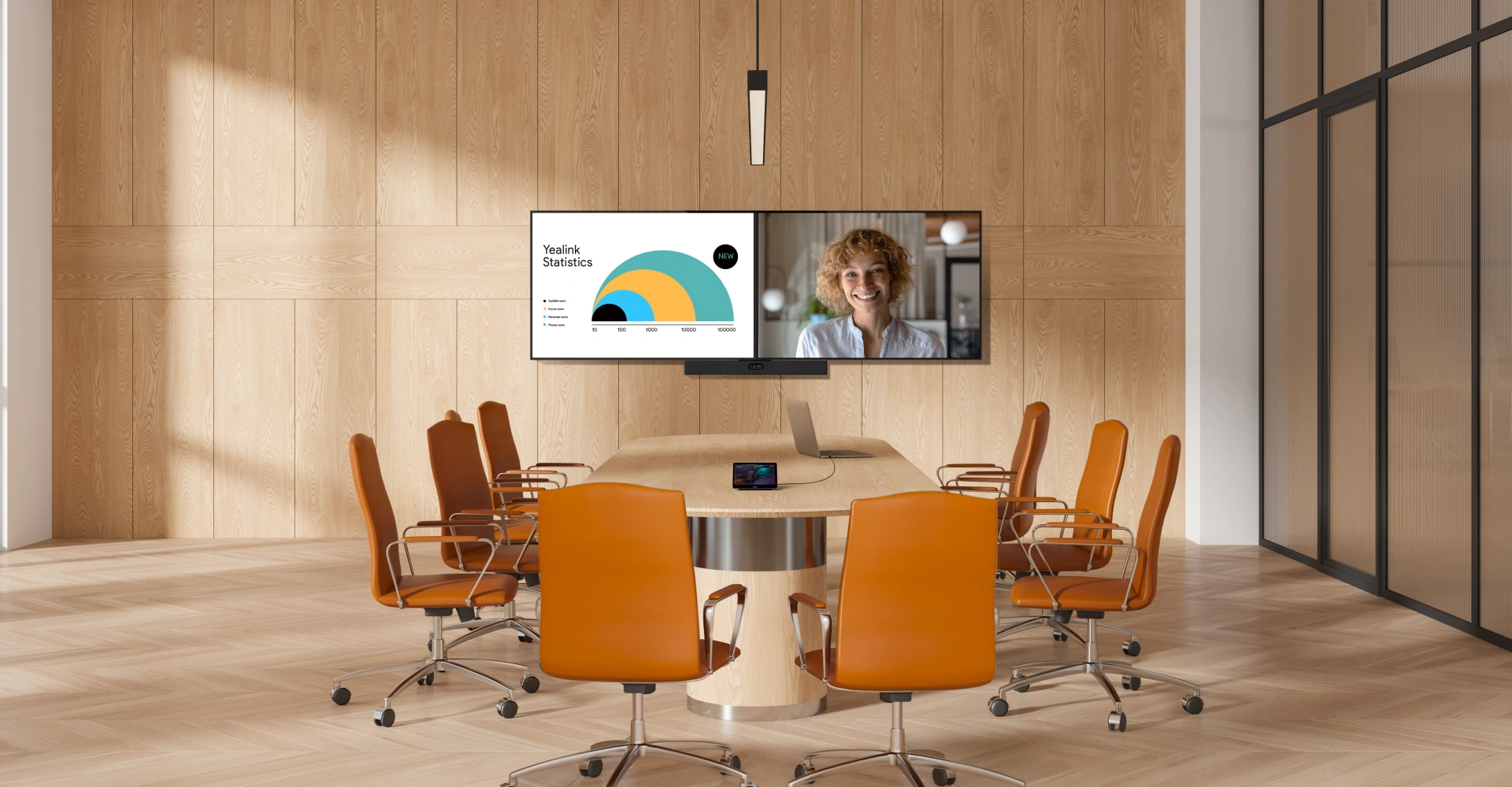 Modern conference room with a round wooden table, eight orange chairs, a large wall-mounted screen displaying a presentation and a video call, wooden flooring, and a glass wall on the right.