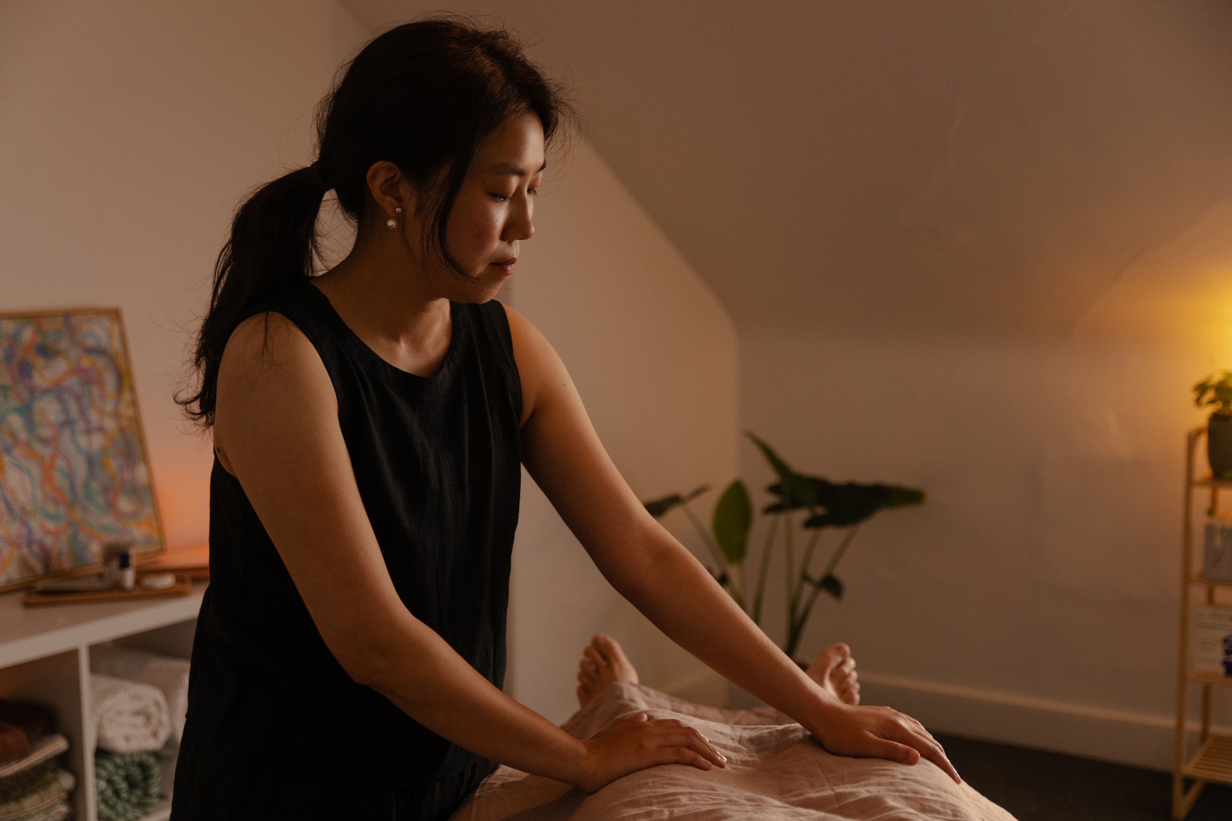 Woman giving a massage in a dimly lit room with plants and a bookshelf.
listen to soft tissue, following the body, craniosacral therapy, hobart, tasmania