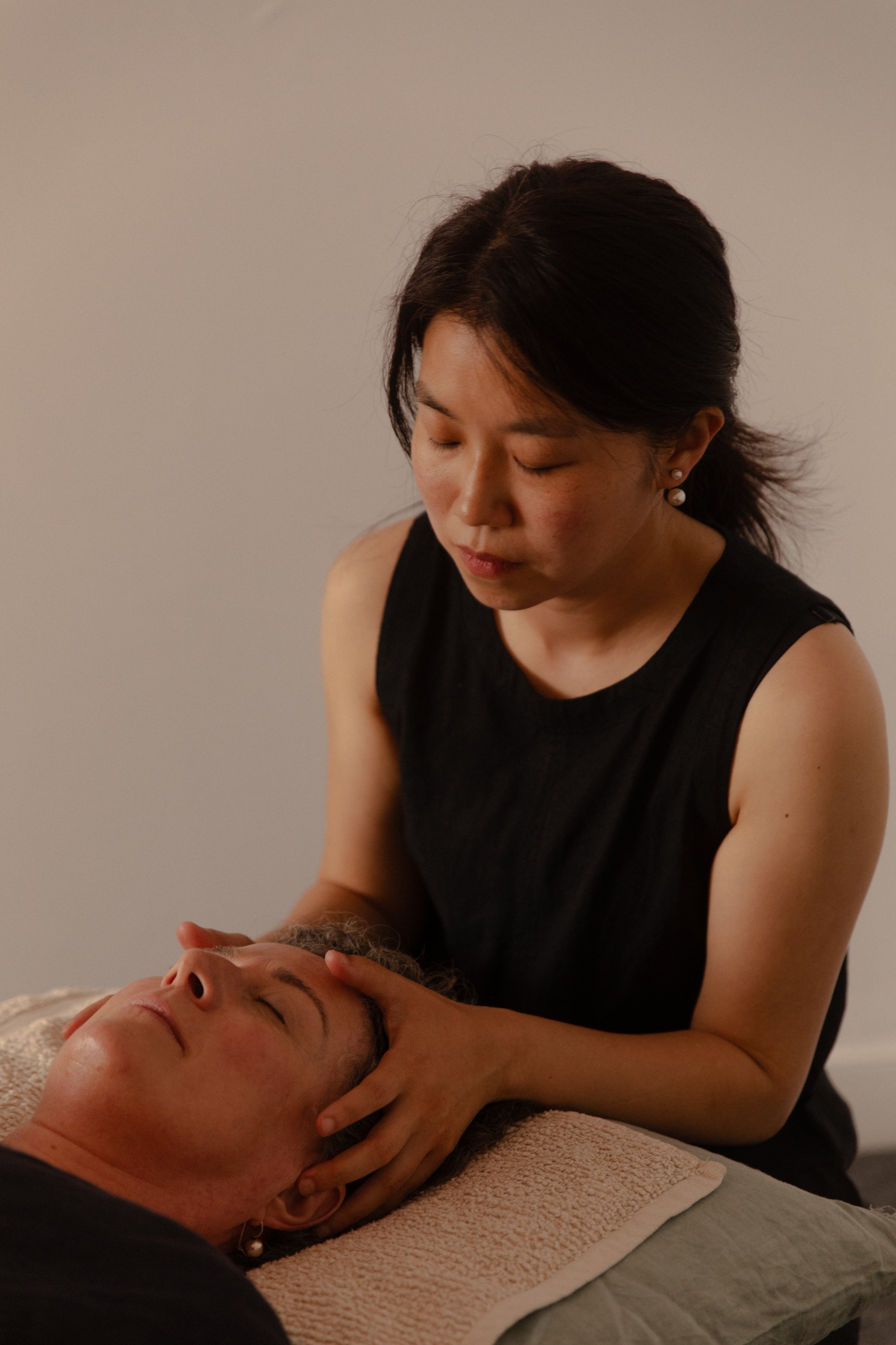 A woman providing craniosacral therapy. nervous system led touch, cranio bone, frontal bone, headache, stress, anxiety