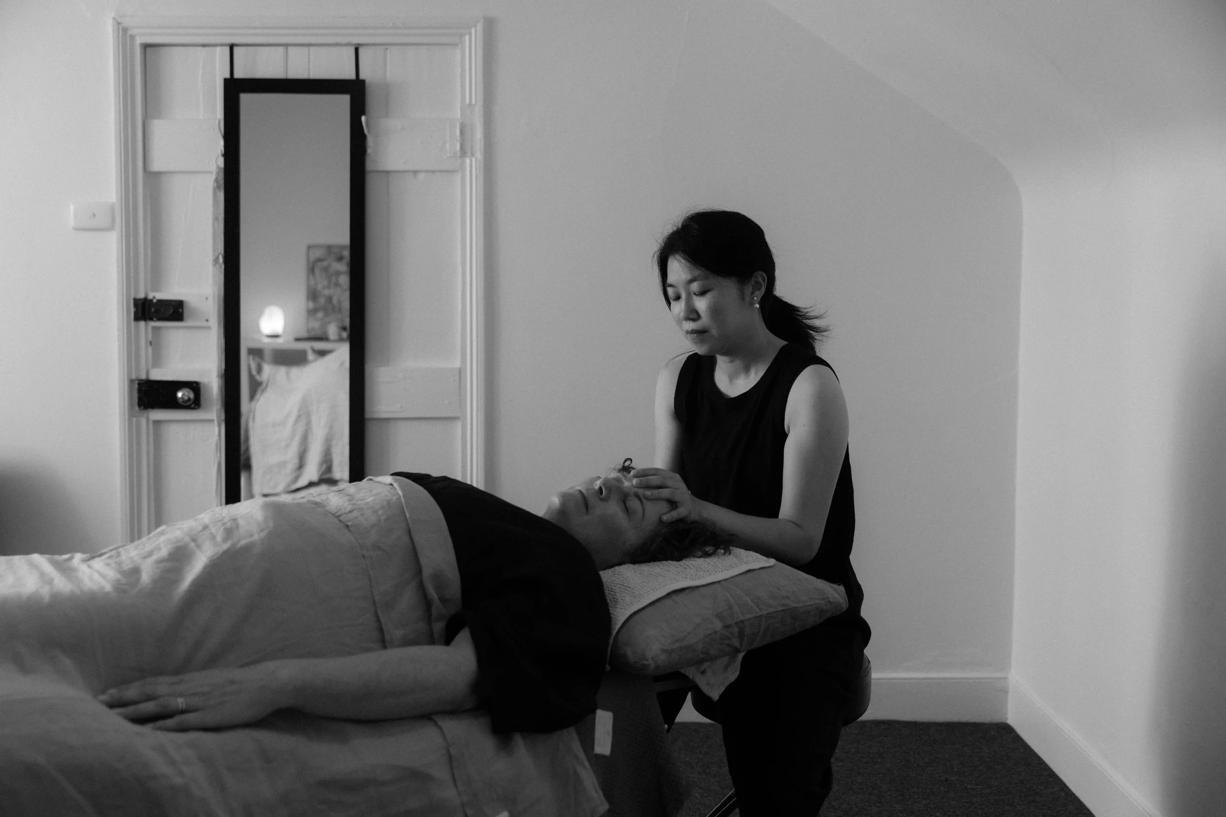 A woman receiving a calm relax treatment from craniosacral therapy practitioner