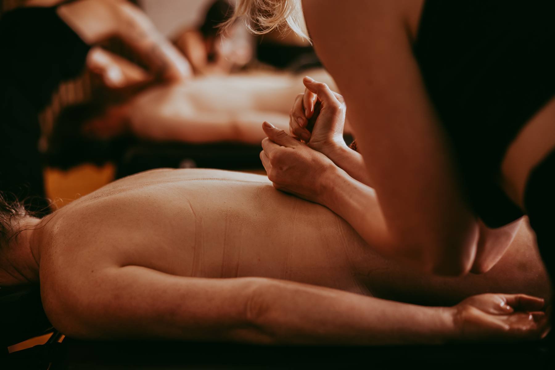 Close-up of a person receiving a massage on their back from a massage therapist.