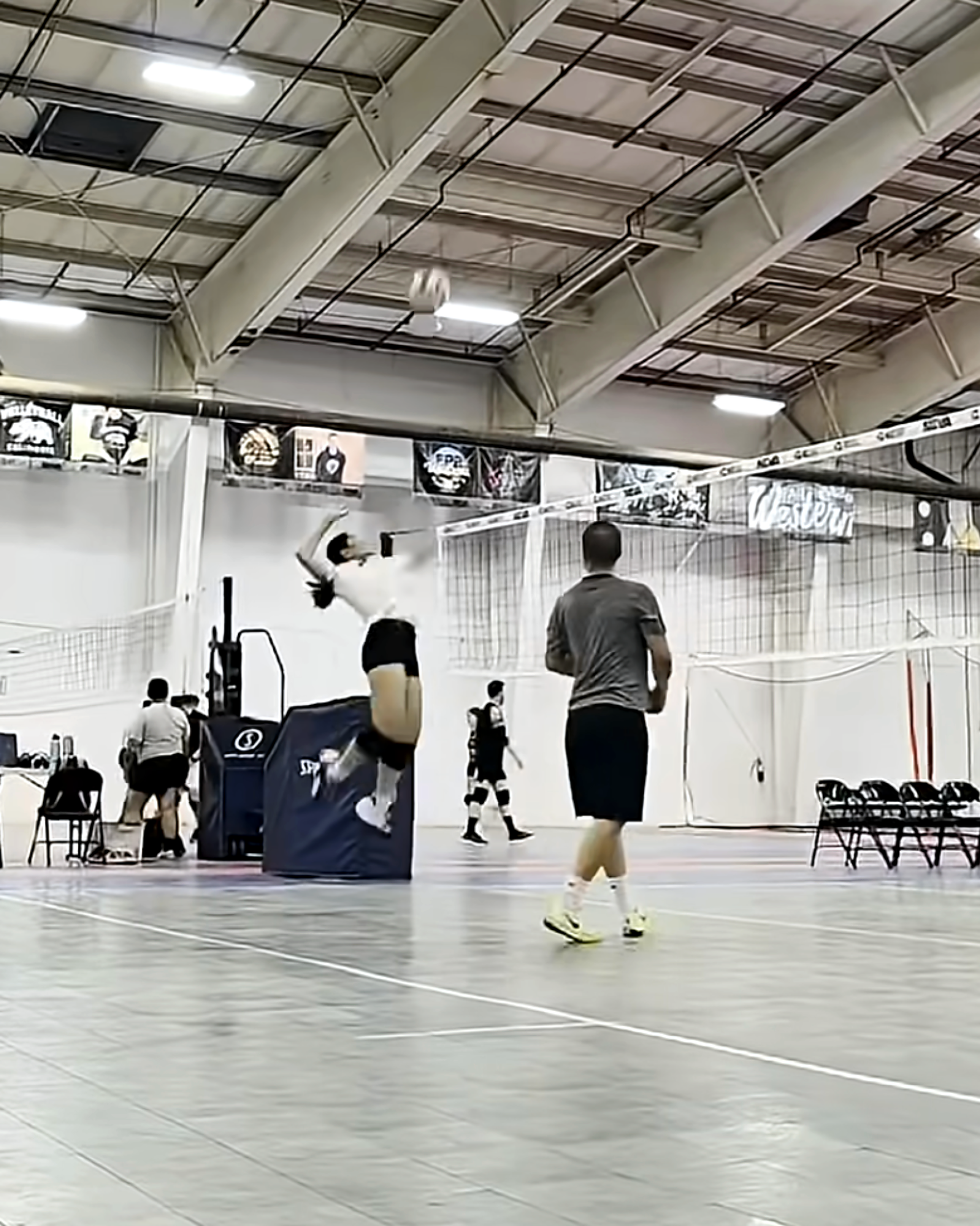 Athlete jumping to hit the ball during an indoor volleyball training rep.