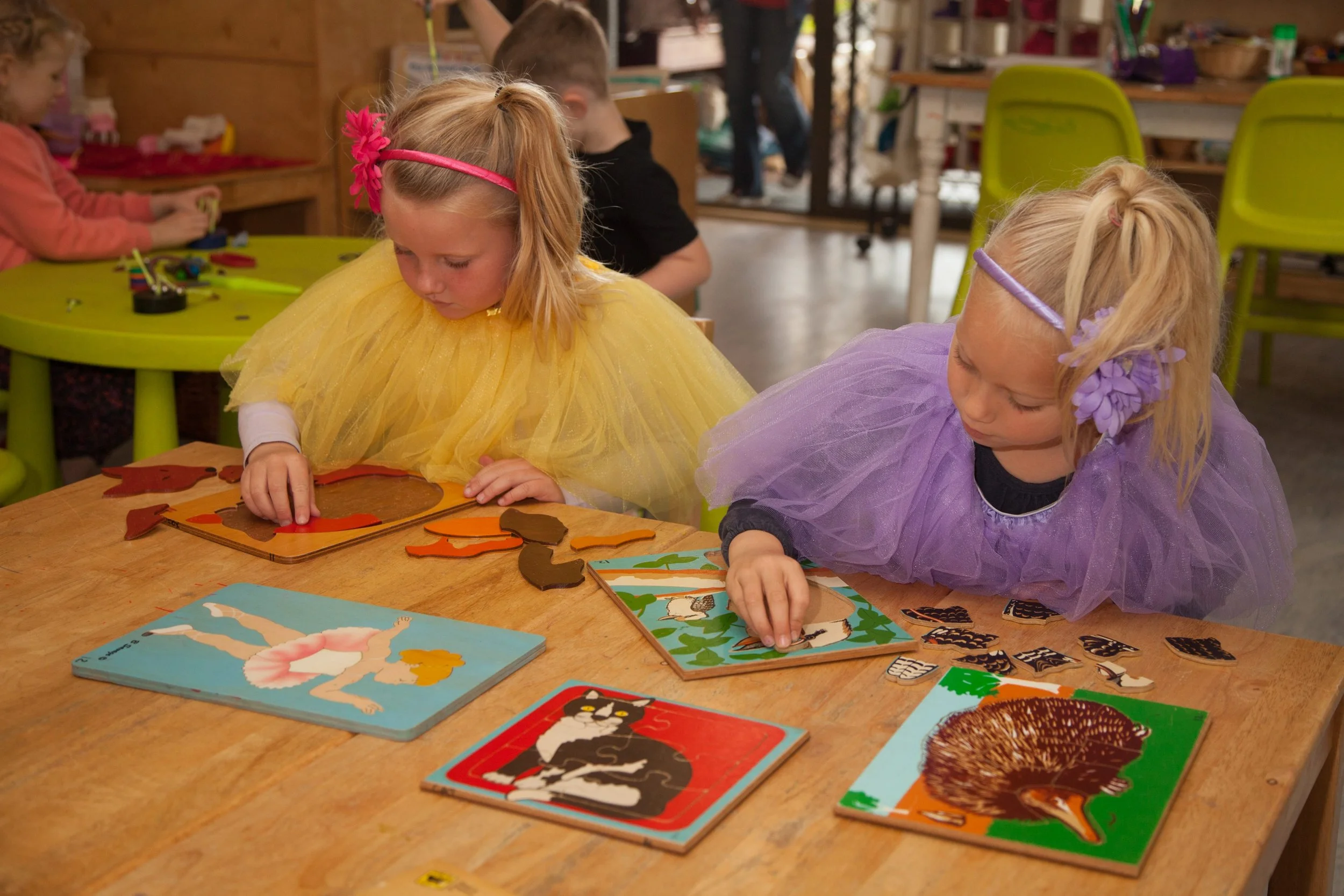 Children completing puzzles and early learning activities together in the Belugas room