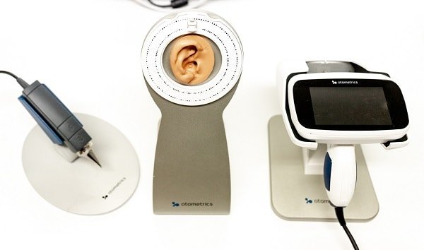 Dental tools, including a dental drill, a model of a ear, and a dental scanner.