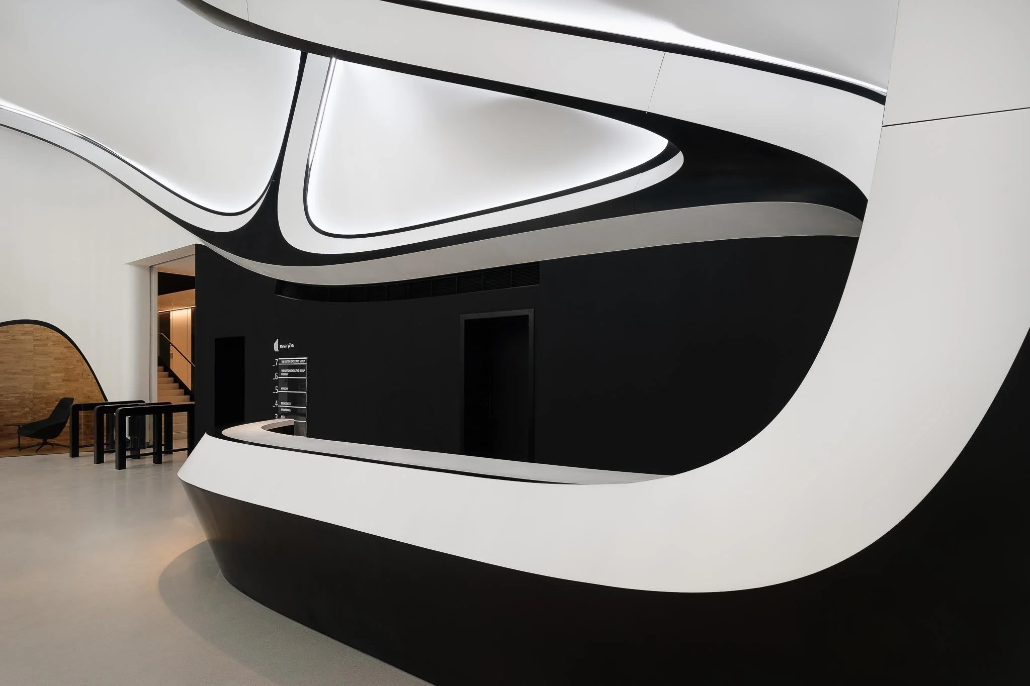 Futuristický interiér administrativní budovy s organickými černo-bílými tvary a čistými liniemi.