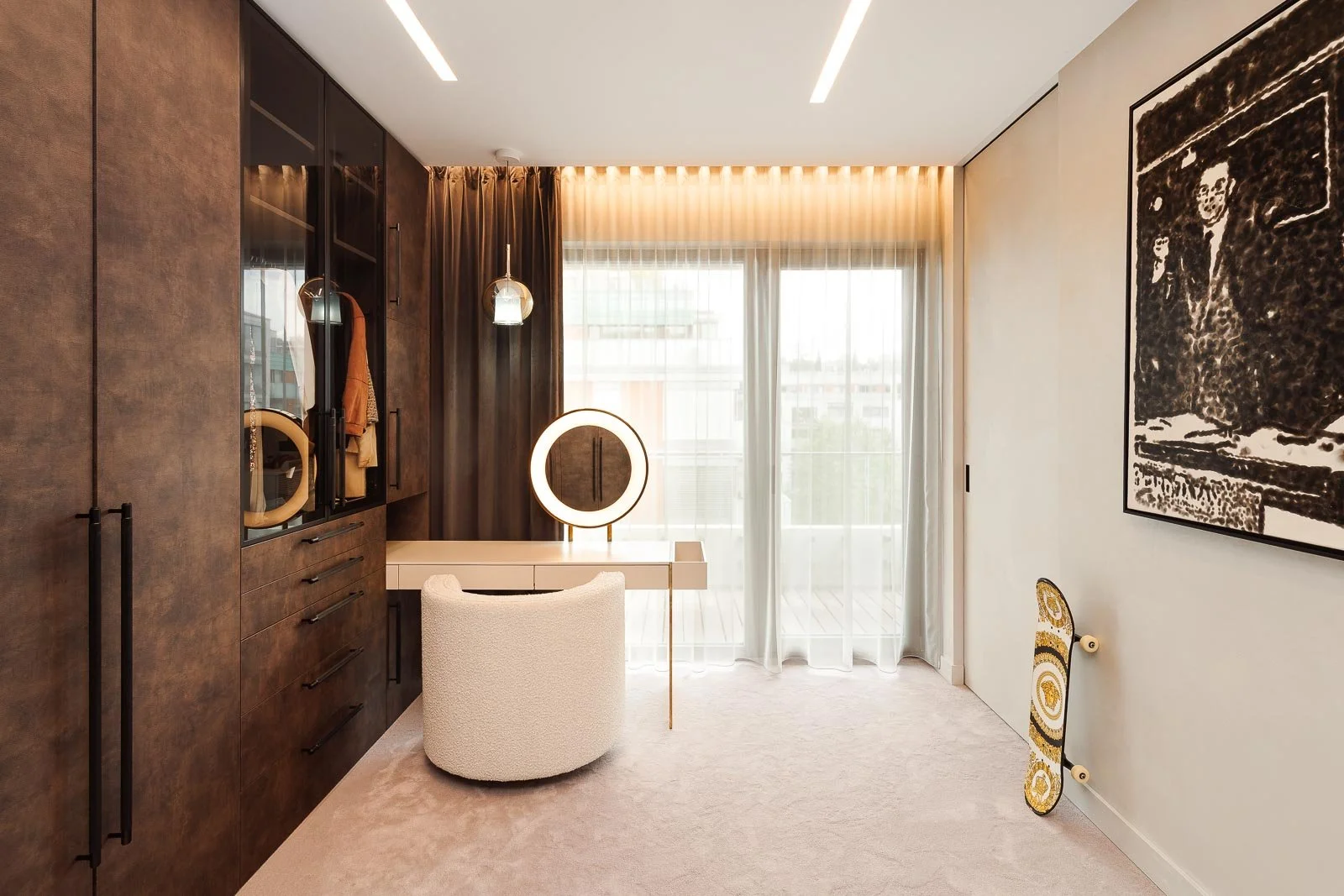 Luxusní šatna s dřevěným dekorem, podsvíceným kruhovým zrcadlem a moderním čalouněným taburetem.