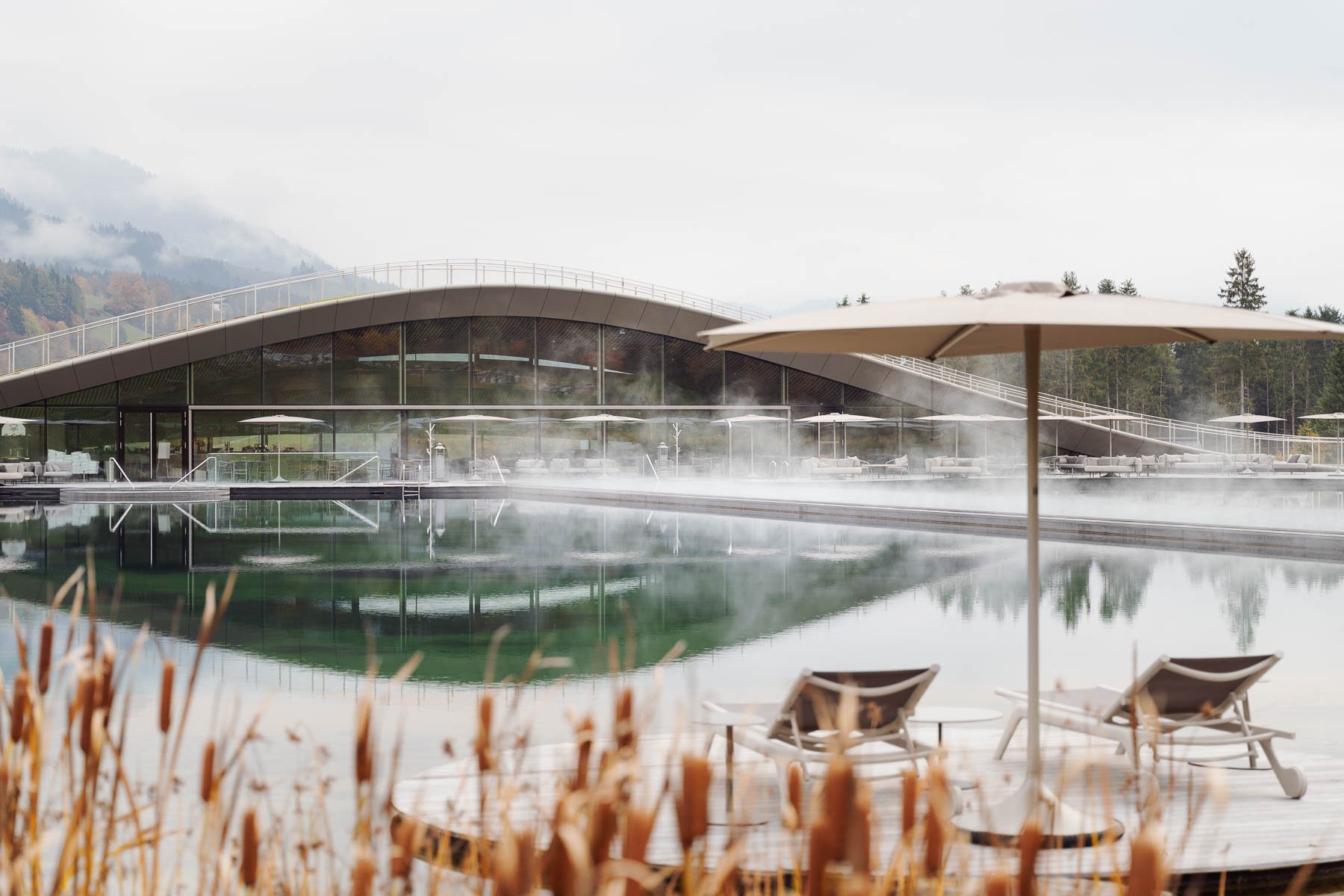 Krallerhof spa pool reflecting surrounding mountains.