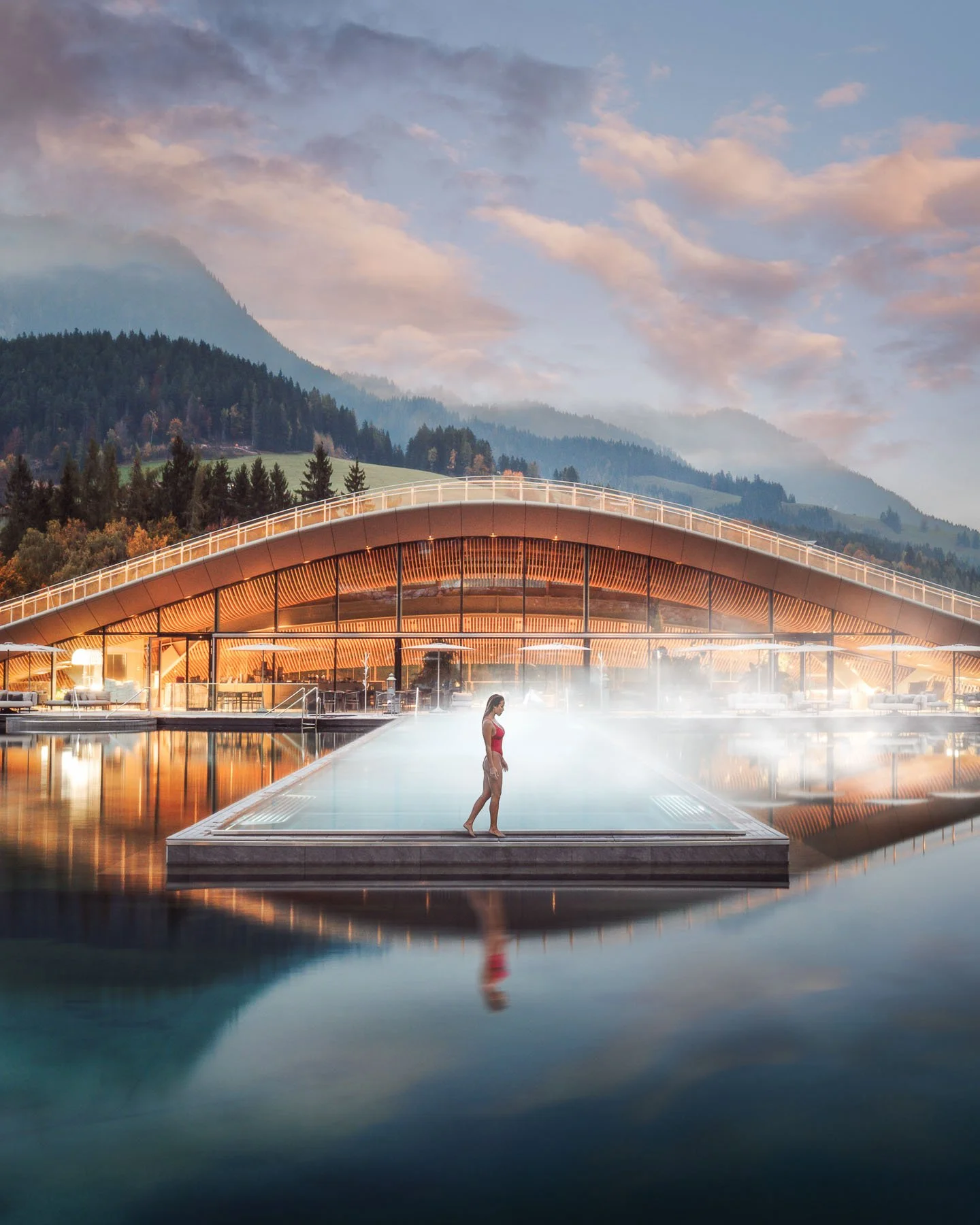 Evening atmosphere at Krallerhof ATMOSPHERE Spa with glowing infinity pool and warm interior light.