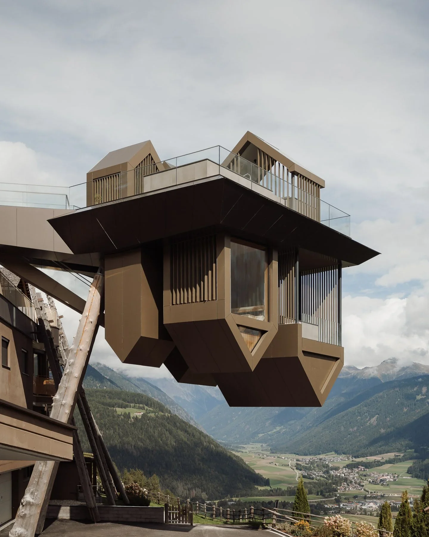 Unikátní architektonický objekt hotelu Hubertus ve tvaru hranolu, který vyčnívá nad sráz s výhledem do horského údolí.