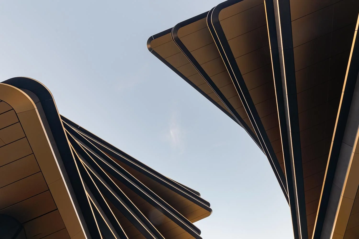 Detailní záběr na osvětlené hrany moderního střešního přesahu budovy Masaryčka.