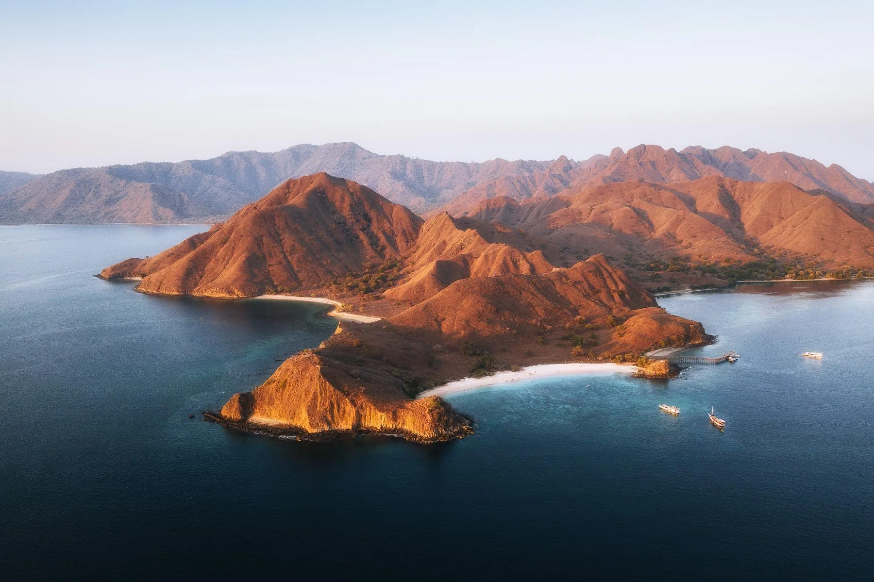 Letecký pohled na tropické ostrovy, tyrkysové laguny a členité pobřeží Indonésie.