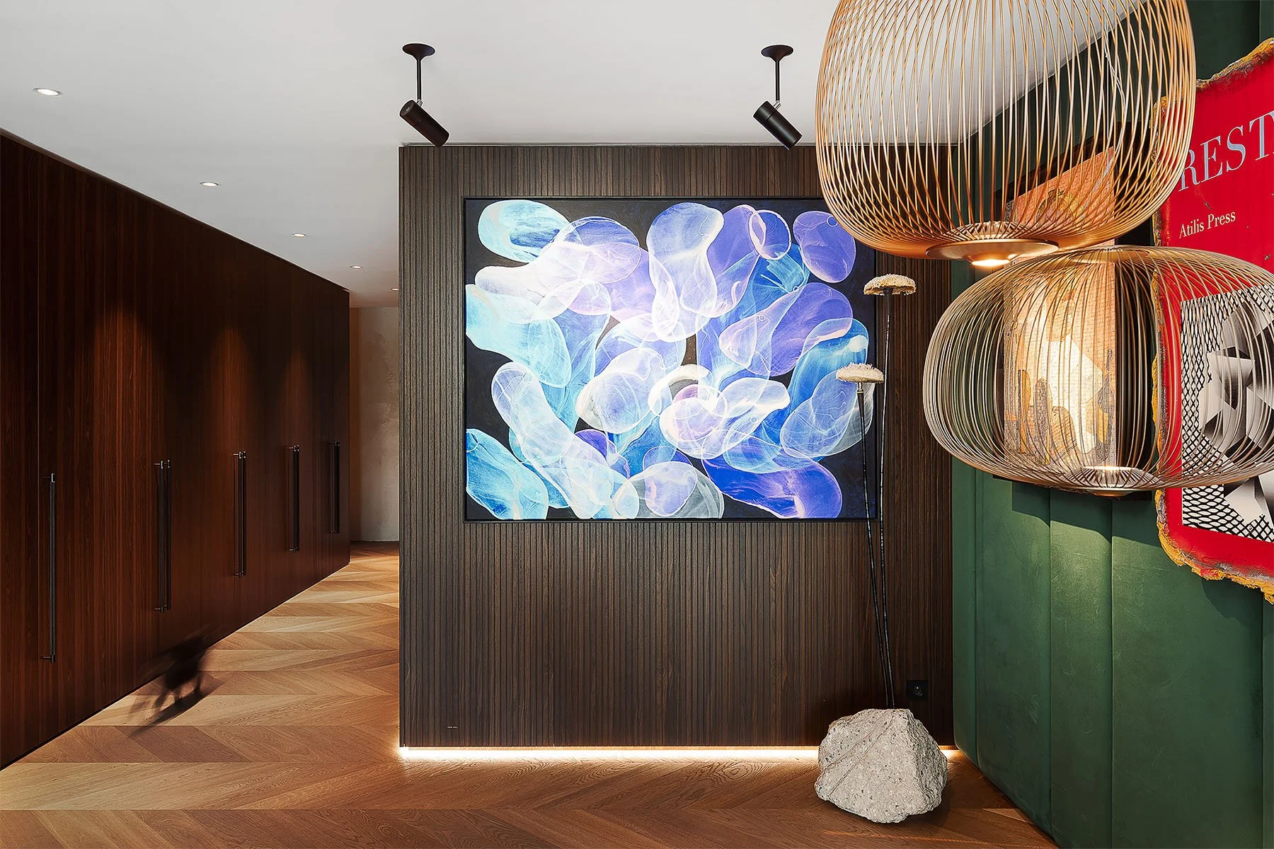 Moderní předsíň s dřevěným lamelovým obkladem a výrazným modrým abstraktním obrazem.