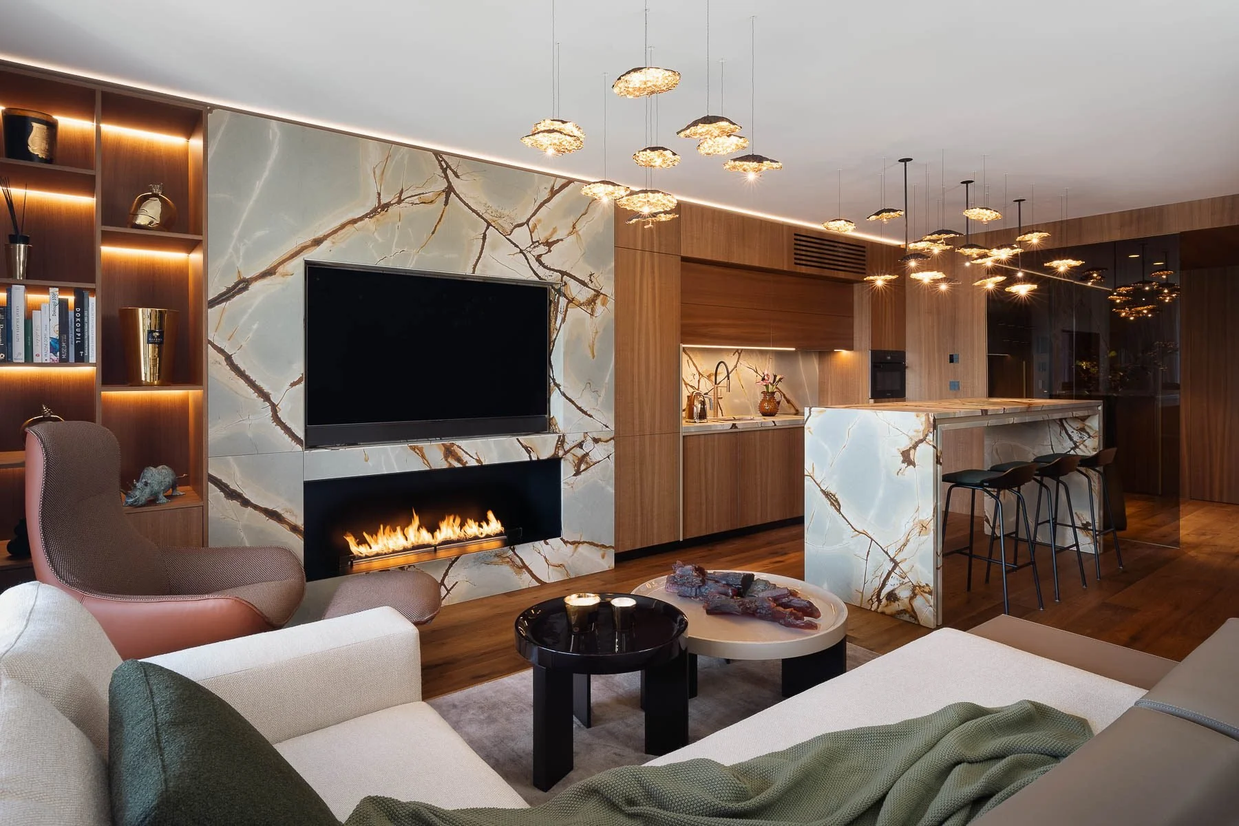 Moderní interiér obývacího pokoje s mramorovým krbem, béžovou pohovkou, designová kuchyně.