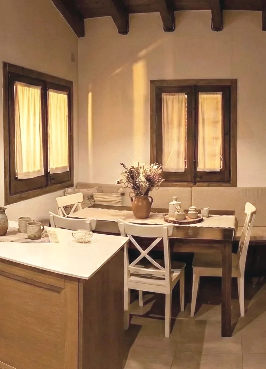 Comedor con banco a medida de madera en reforma de casa de montaña en La Cerdanya. Diseño fluido que se integra con el salón para maximizar el número de comensales.