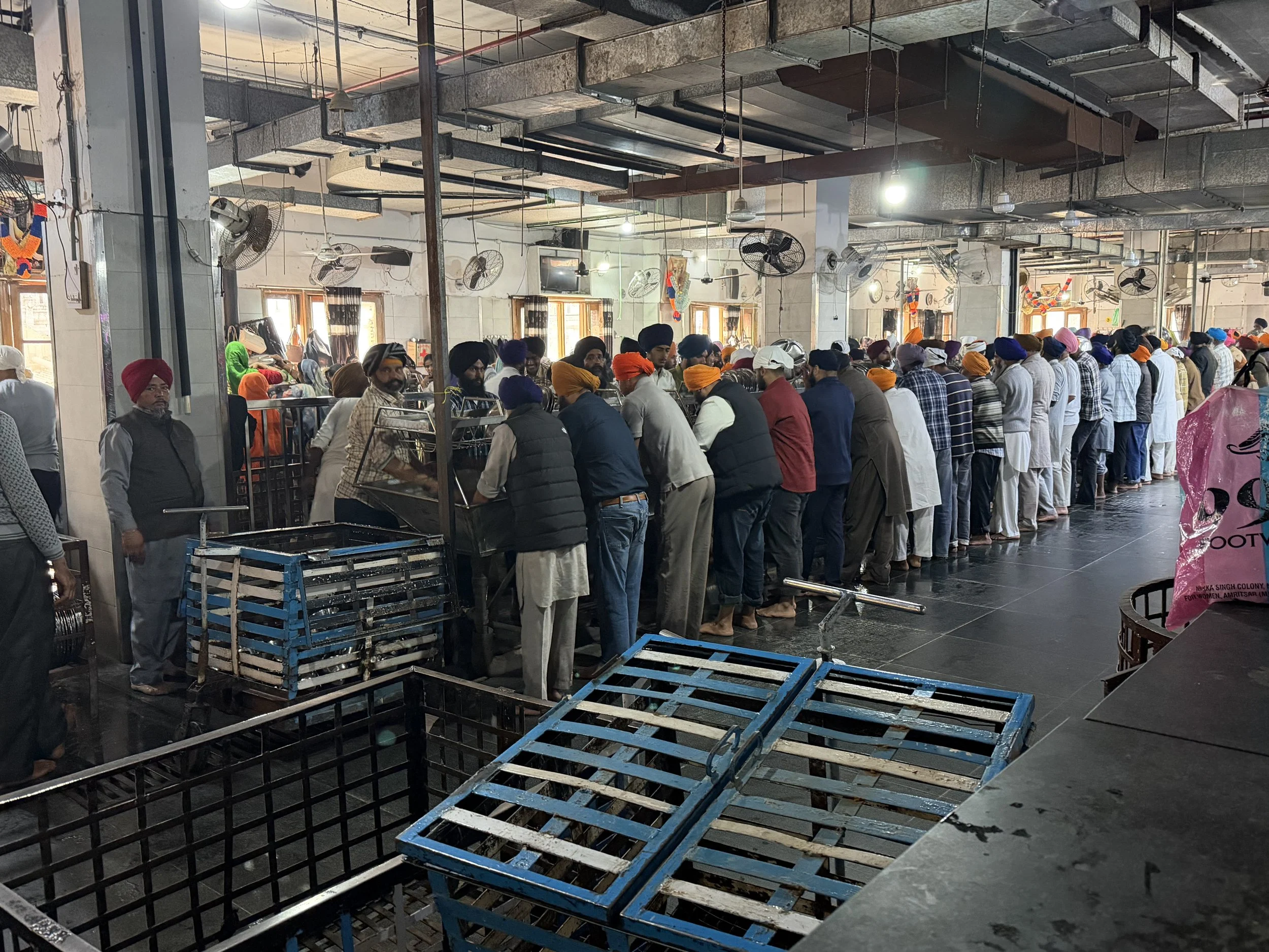 Volunteers cleaning metal trays in the langar kitchen at the Golden Temple in Amritsar