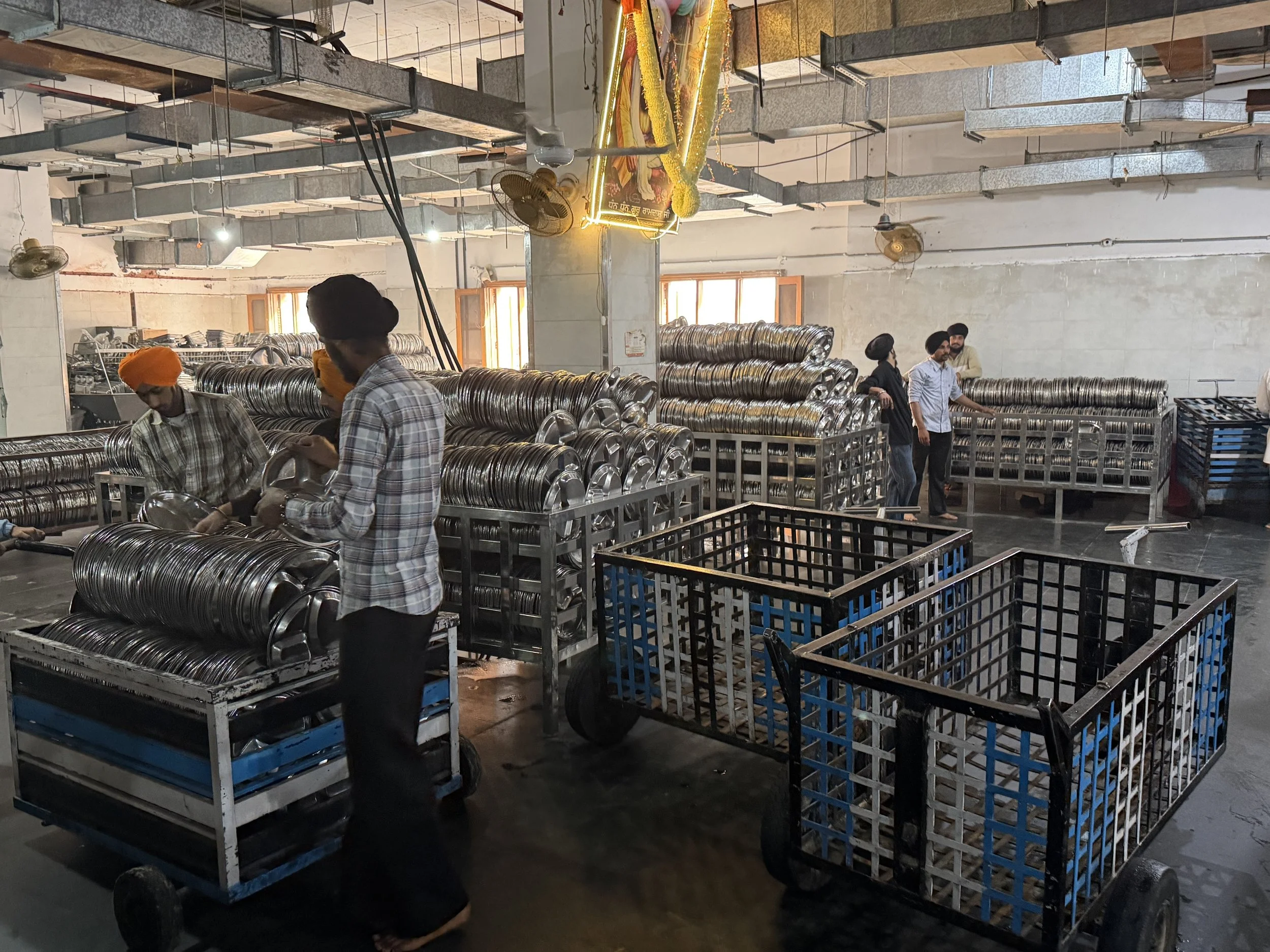 Volunteers cleaning metal trays in the langar kitchen at the Golden Temple in Amritsar