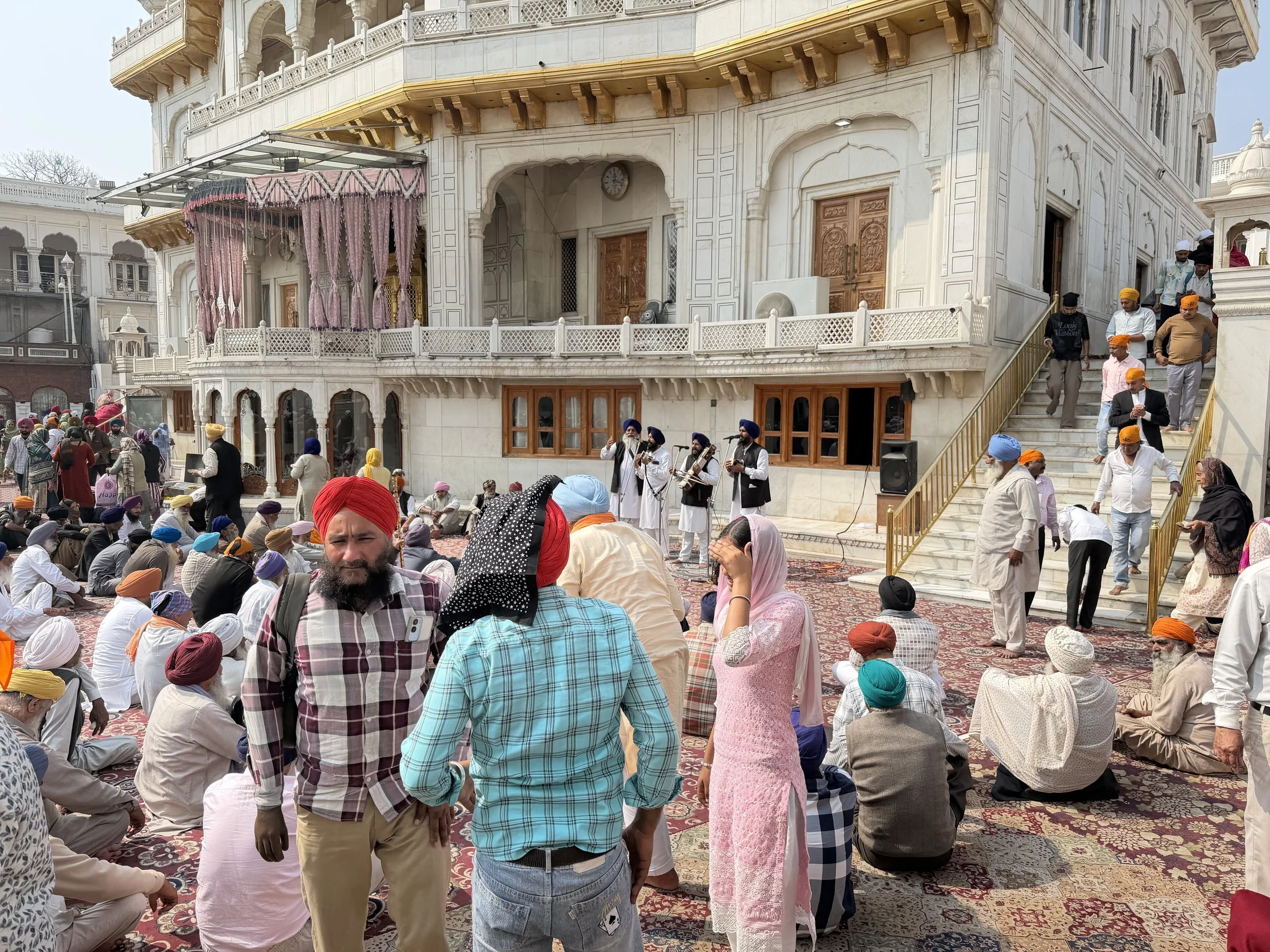 Pilgrims sitting in the courtyard of the Golden Temple complex in Amritsar
