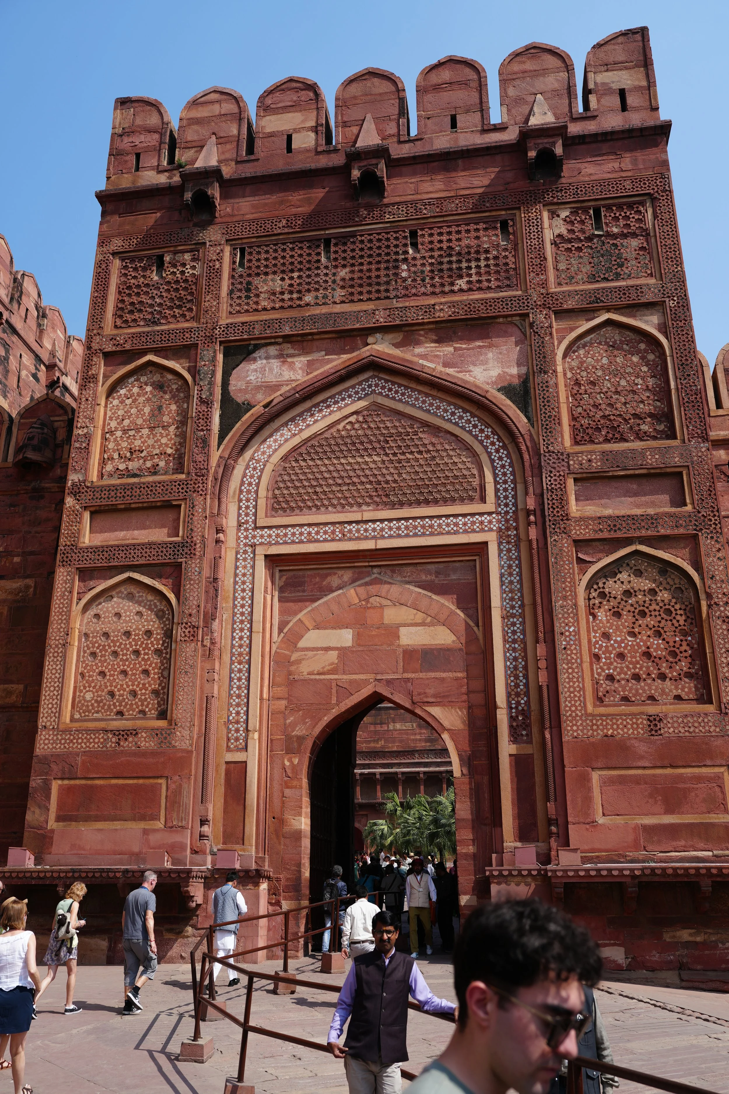Agra Fort entrance gate with massive red sandstone walls and defensive towers under bright afternoon sun