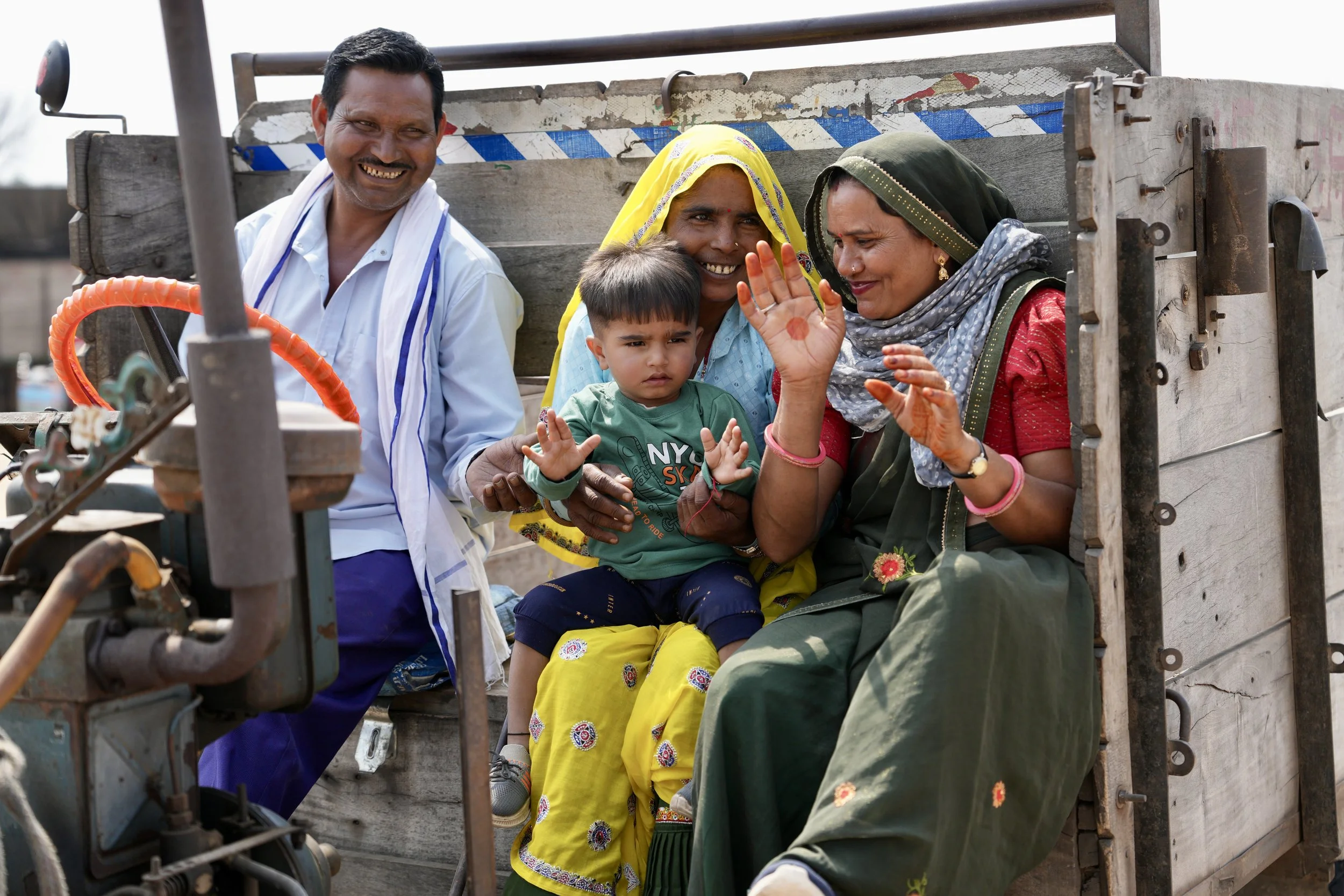 Family riding in tractor trailer in rural Rajasthan India