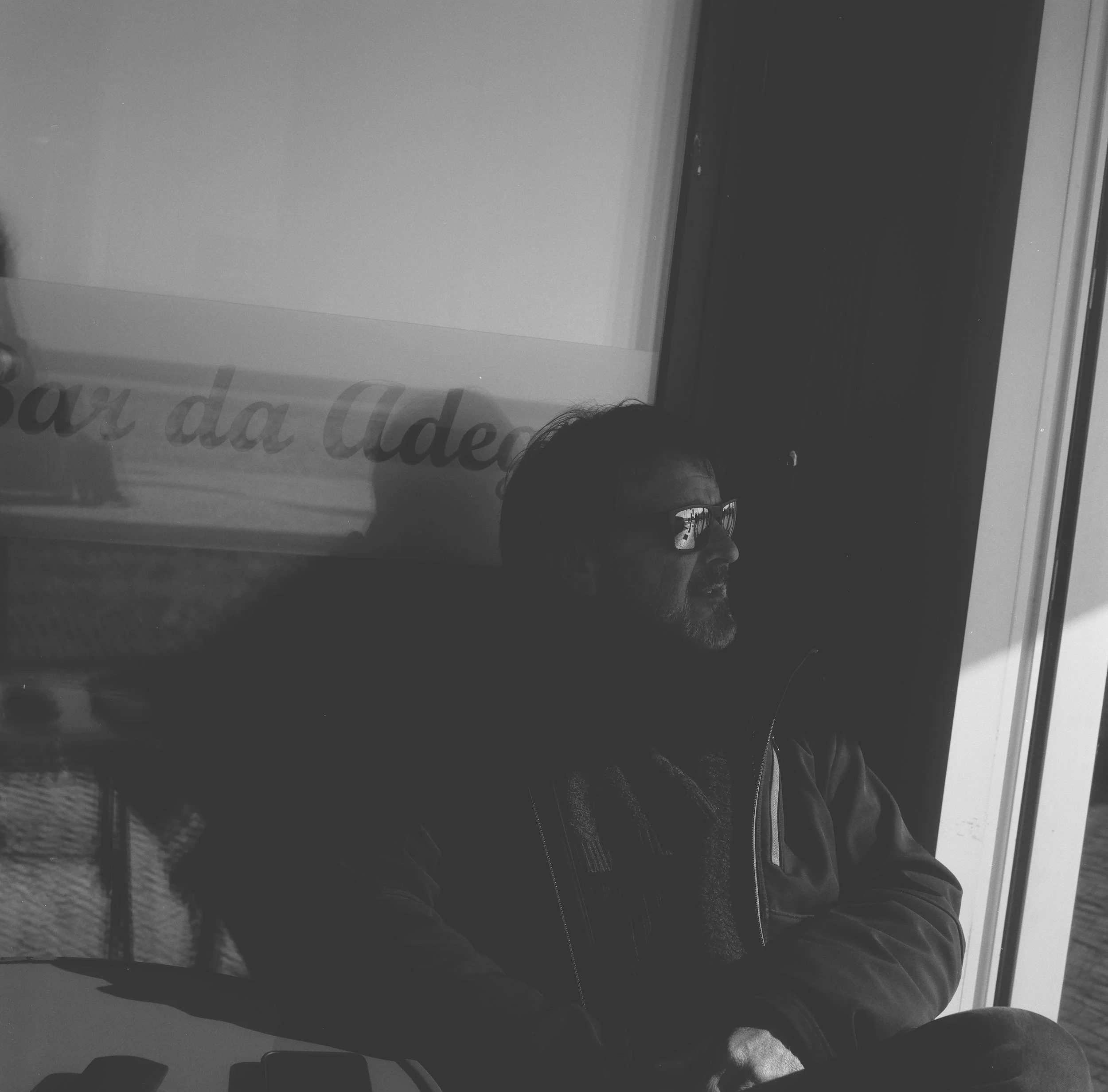 High-contrast black and white film portrait. A study in lighting and restraint, emphasizing the portfolio's philosophy of 'framing what matters.'