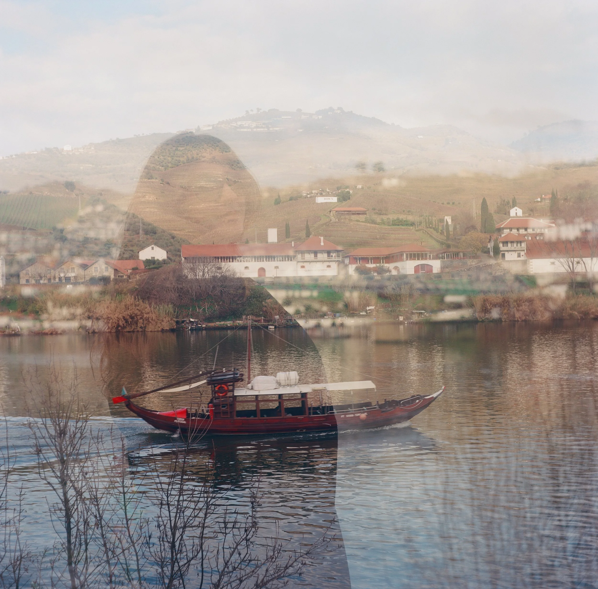 Doble exposure shot on medium format film. Film photography capturing a boat, a girl and river town. A study in perspective and framing the narrative.