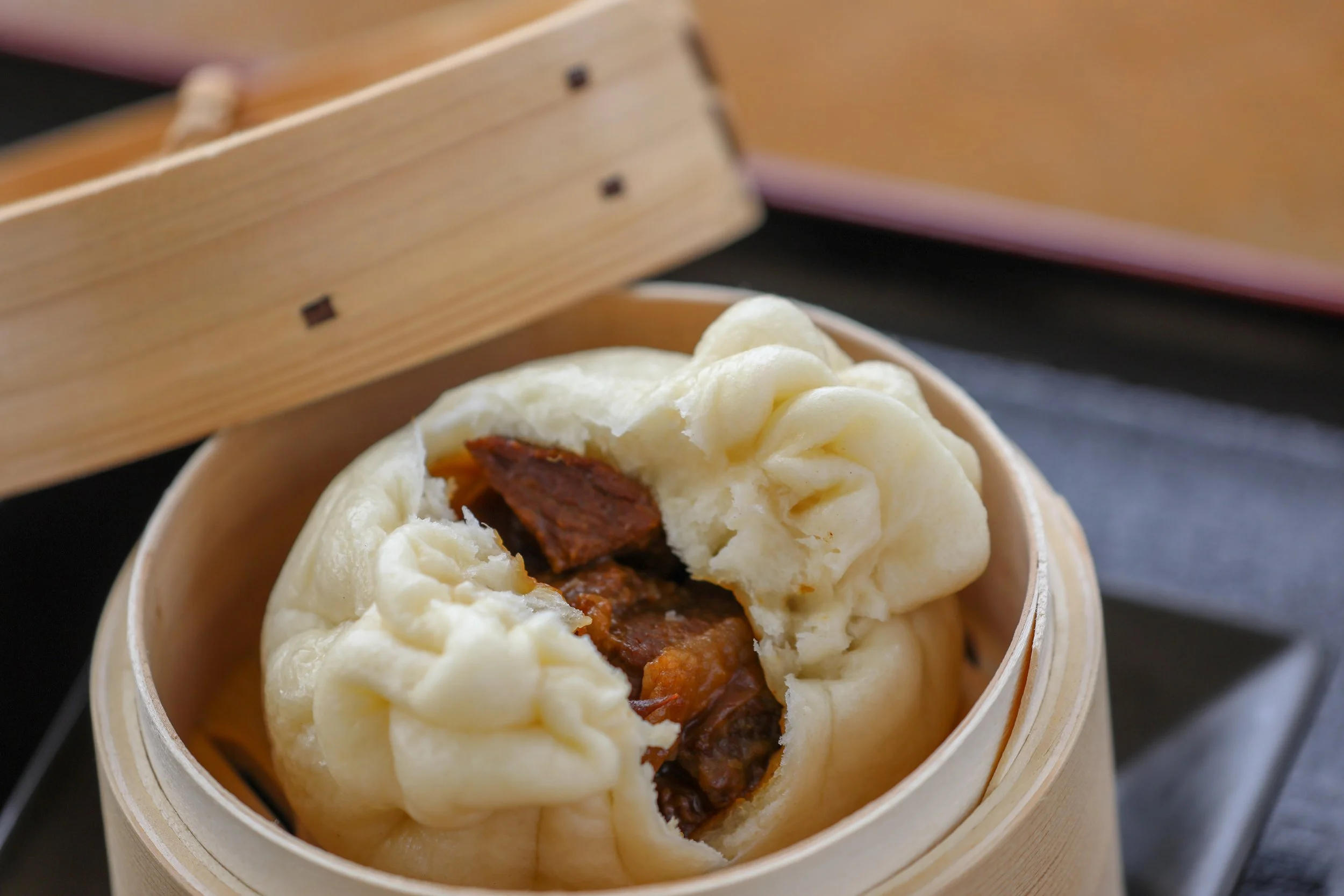 蒸籠の中の肉まんの断面、豚肉の黒牛まん