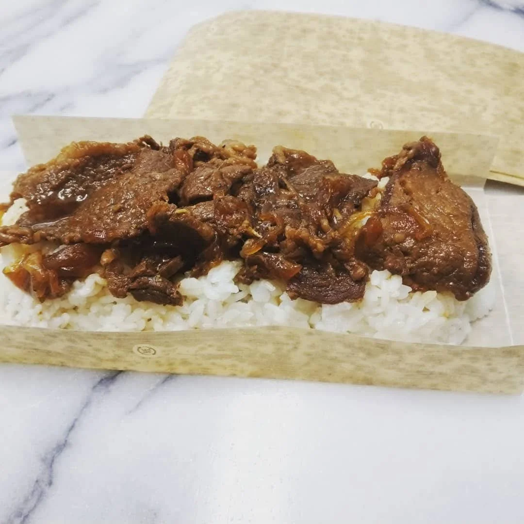白いご飯の上に肉の煮込みがのった弁当