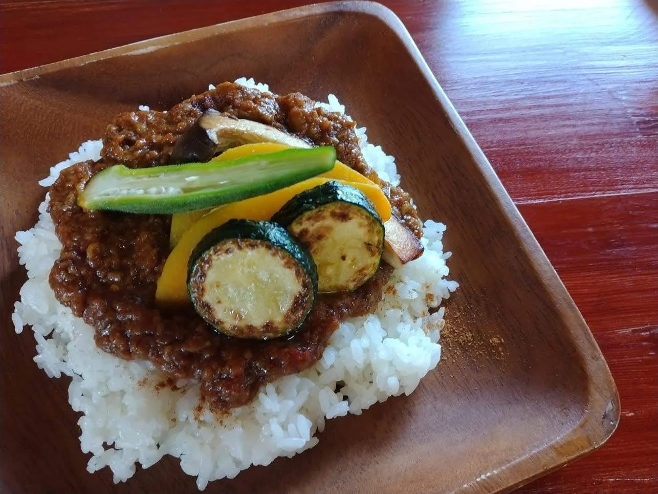 白ごはんの上に野菜とひき肉のソースがのったキーマカレー
