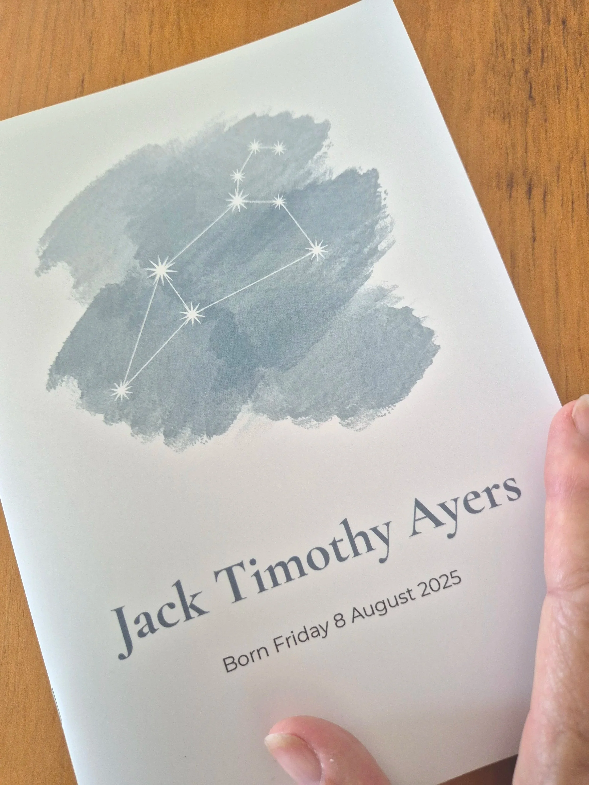A printed card honoring Jack Timothy Ayers on his birthday, August 8, 2025. The card features a watercolor design with the Leo star constellation illustration above his name and birth date.