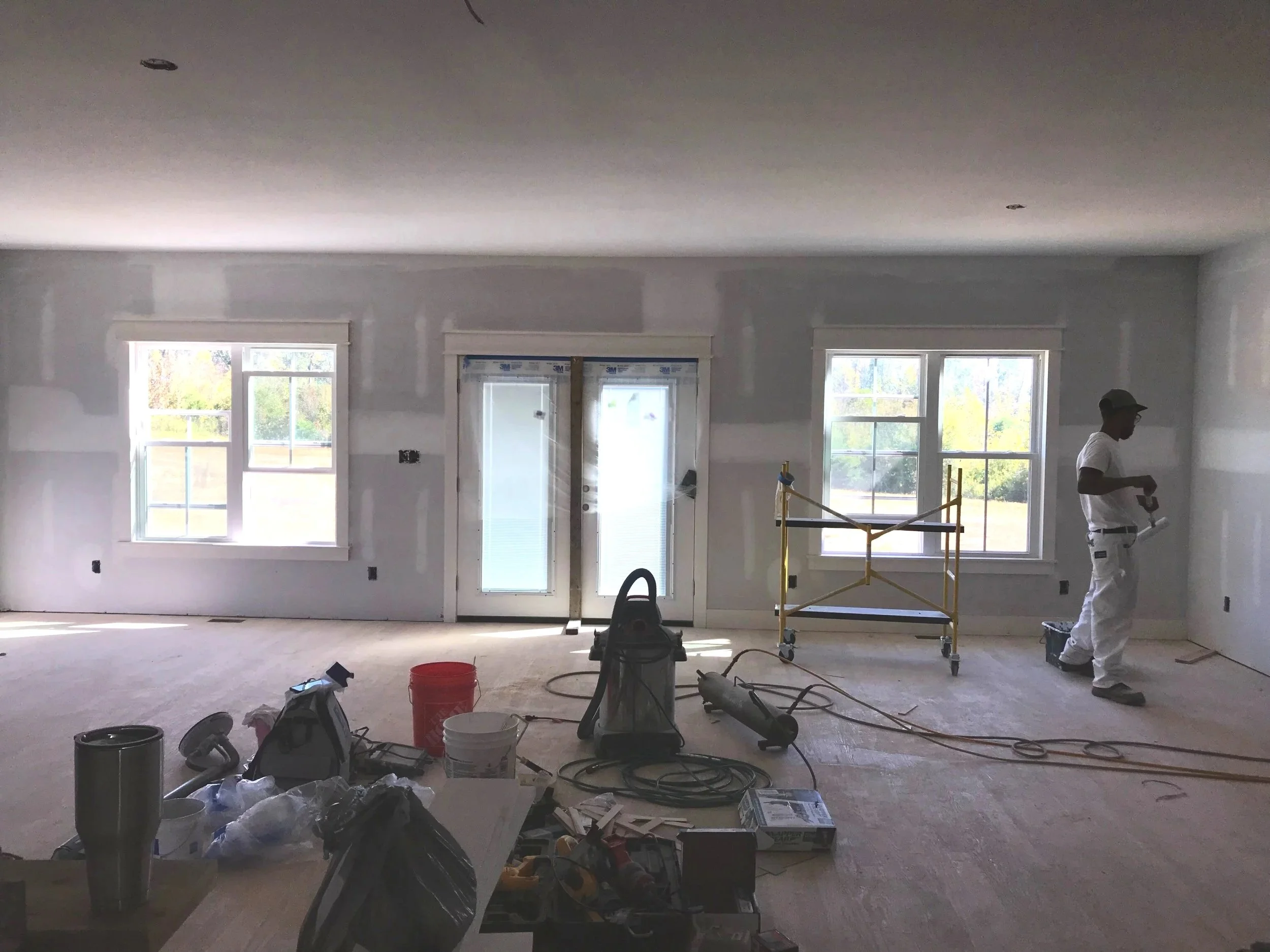 Open living area during a home remodel with tools and materials visible before finishing work.