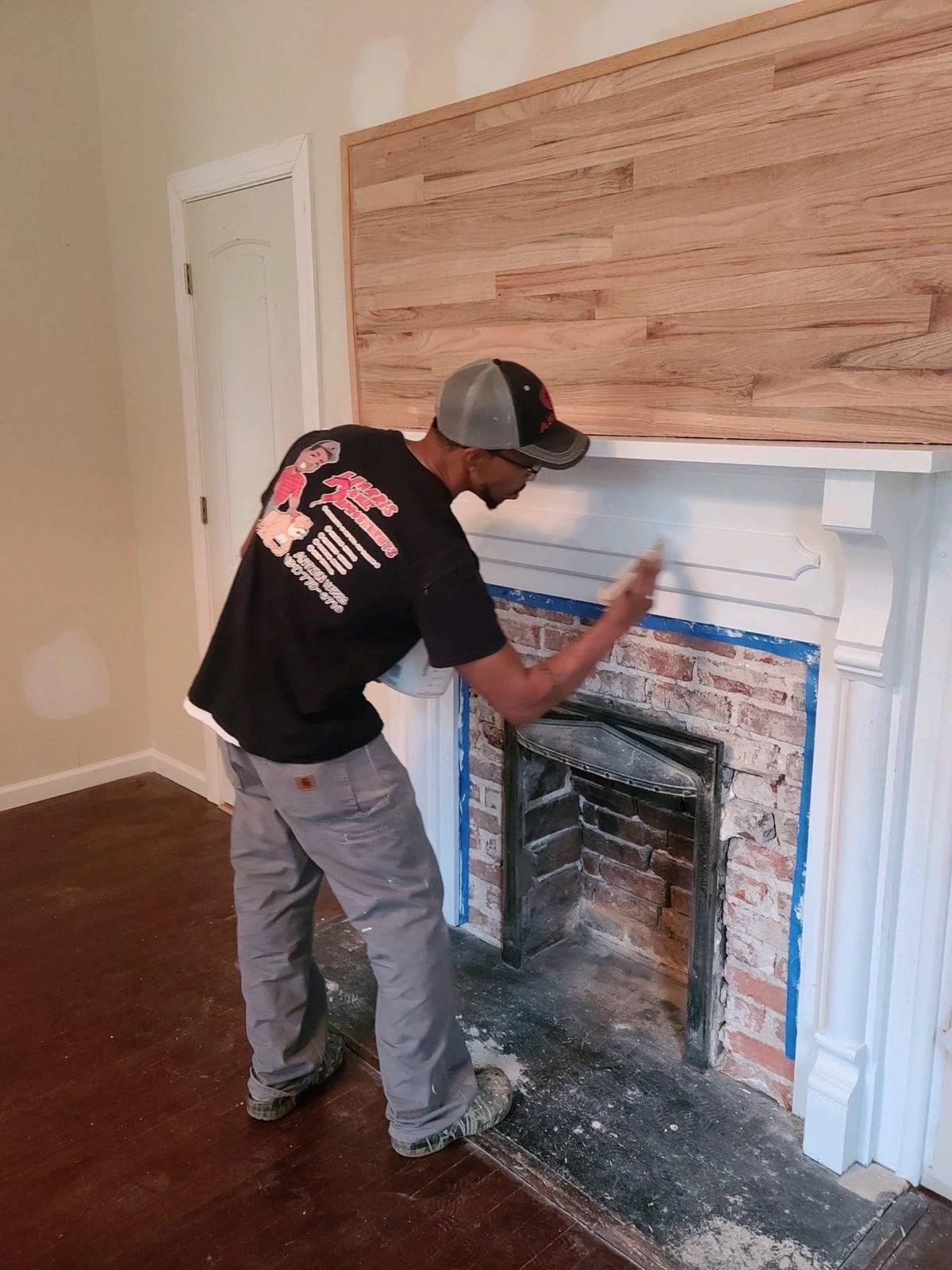 Contractor installing a fireplace surround during a residential renovation project.