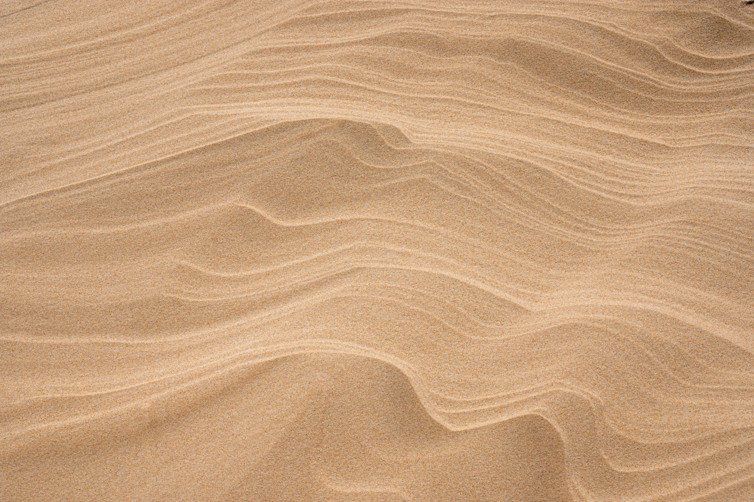 Close-up of sand dunes with fine, rippled patterns.