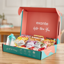 Open box with meal replacement packets lined up in the box, and an empty shaker bottle on the left hand side