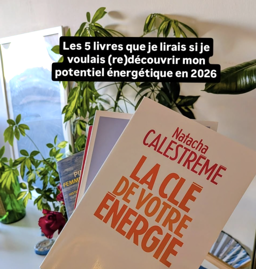 Livre intitulé 'La clé de votre énergie' par Natacha Calestrémé est en avant-plan. En arrière-plan, il y a des plantes vertes d'intérieur et un miroir ou une photo. Sur l'image, il est écrit en français : 'Les 5 livres que je lirais si je voulais (re)découvrir mon potentiel énergétique en 2026'.