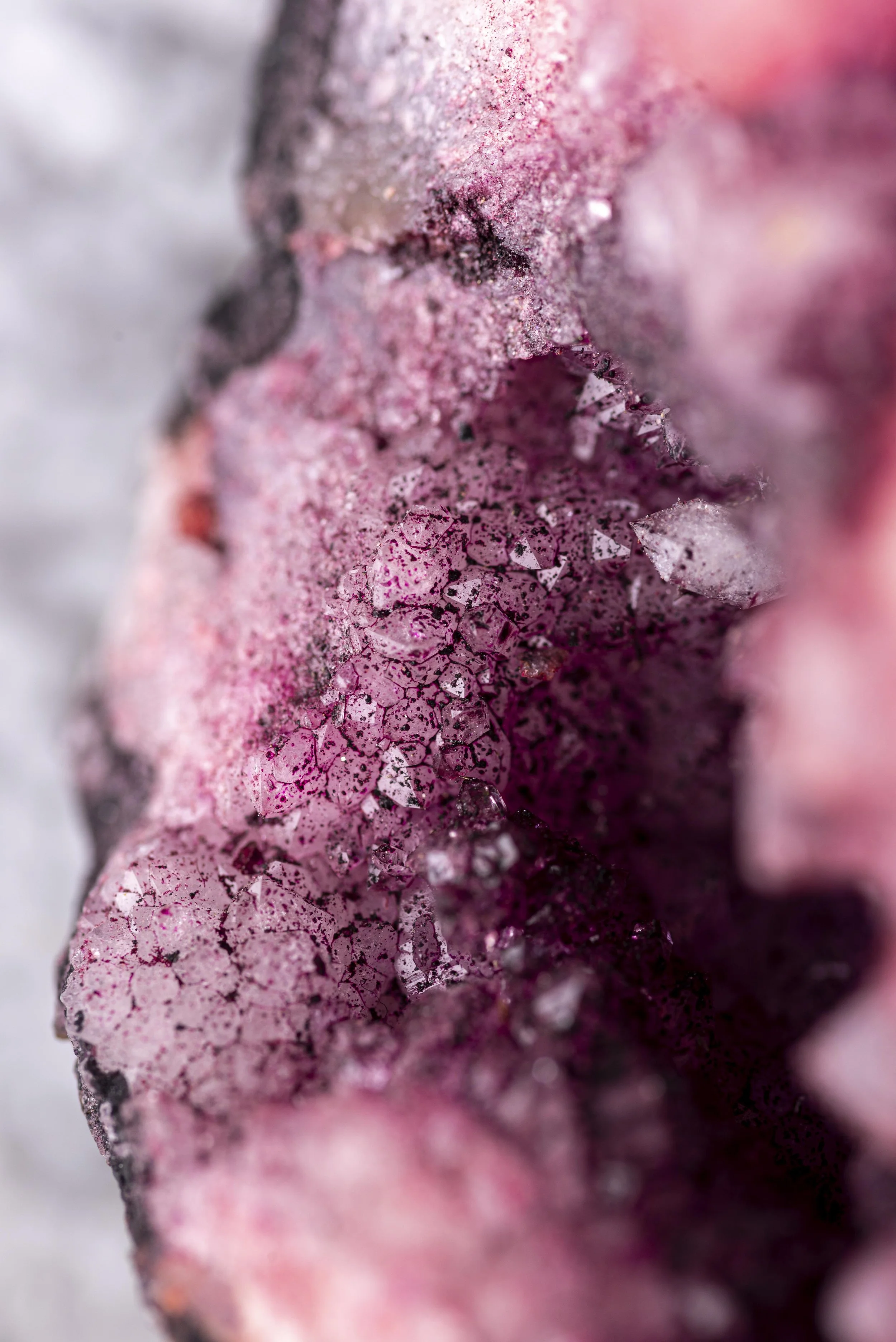 Gros plan de cristaux de glace rose et blanc sur une surface rugueuse.