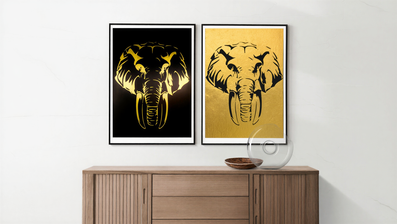 Deux tableaux modernes représentant une tête d'éléphant stylisée, l'un avec un fond noir et des détails dorés, l'autre avec un fond doré et des détails noirs, suspendus au mur au-dessus d'un meuble en bois.