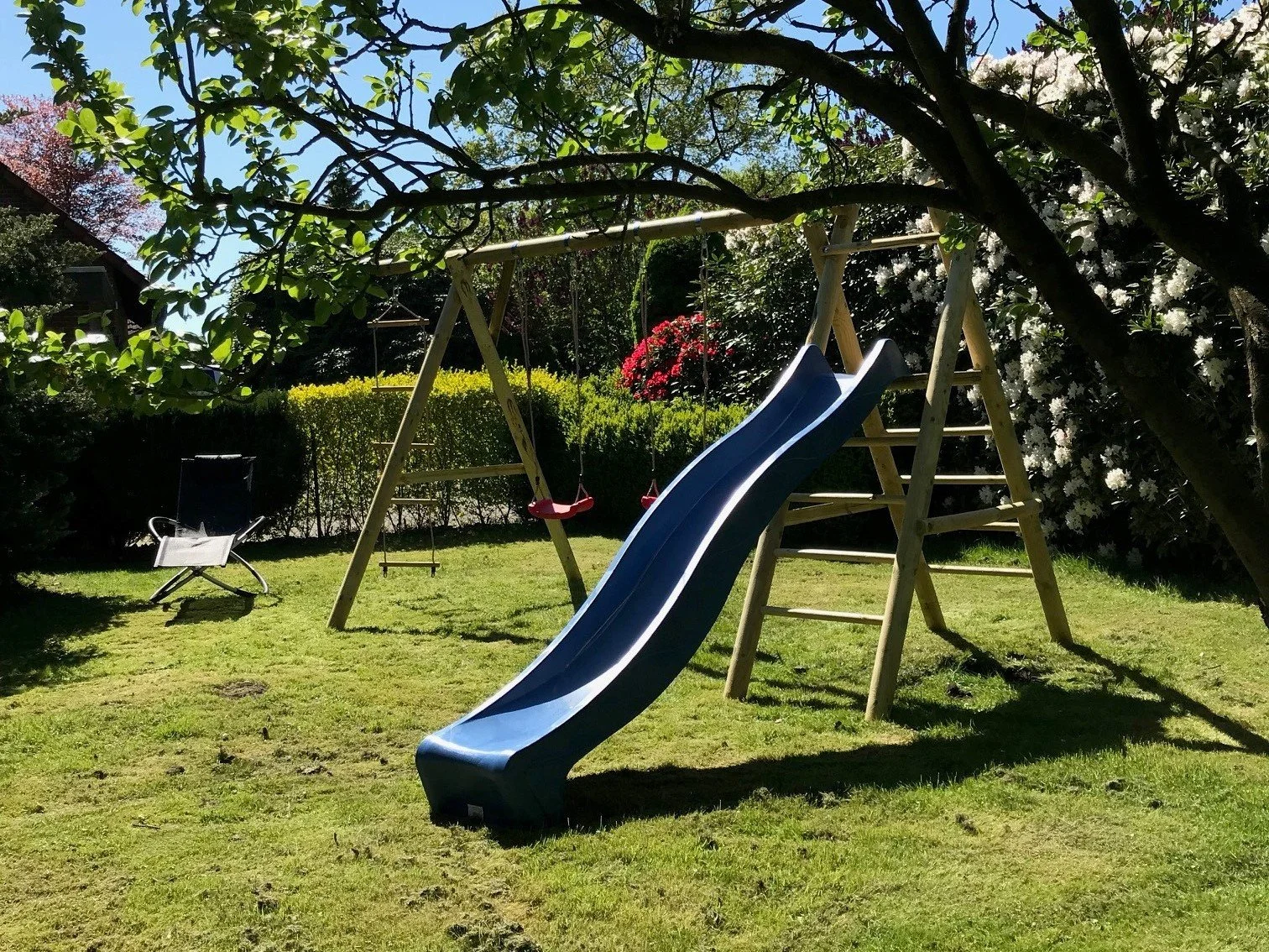 Spielmöglichkeiten mit Schaukel und Rutsche im Garten