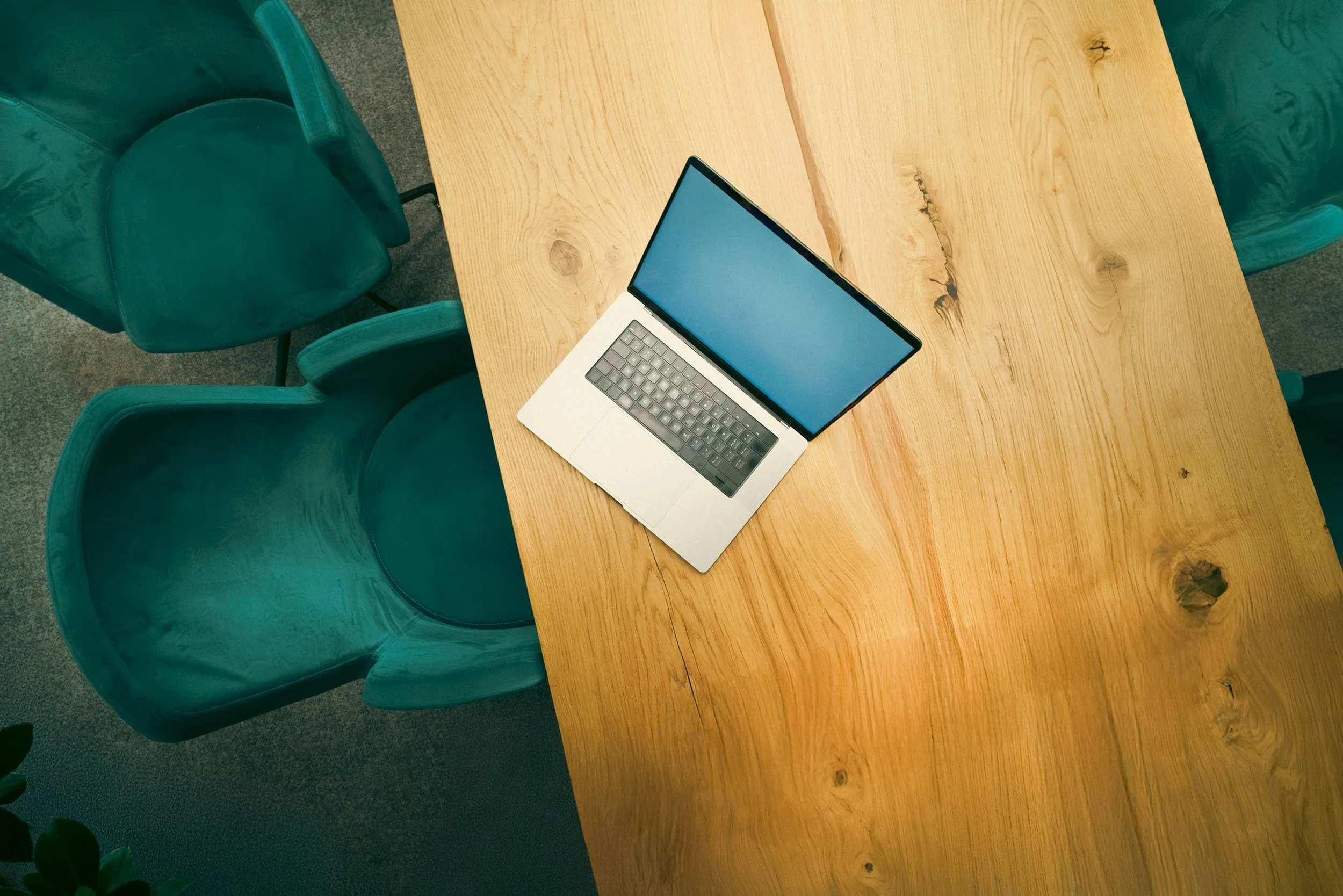 Green chair under wooden desk with a laptop