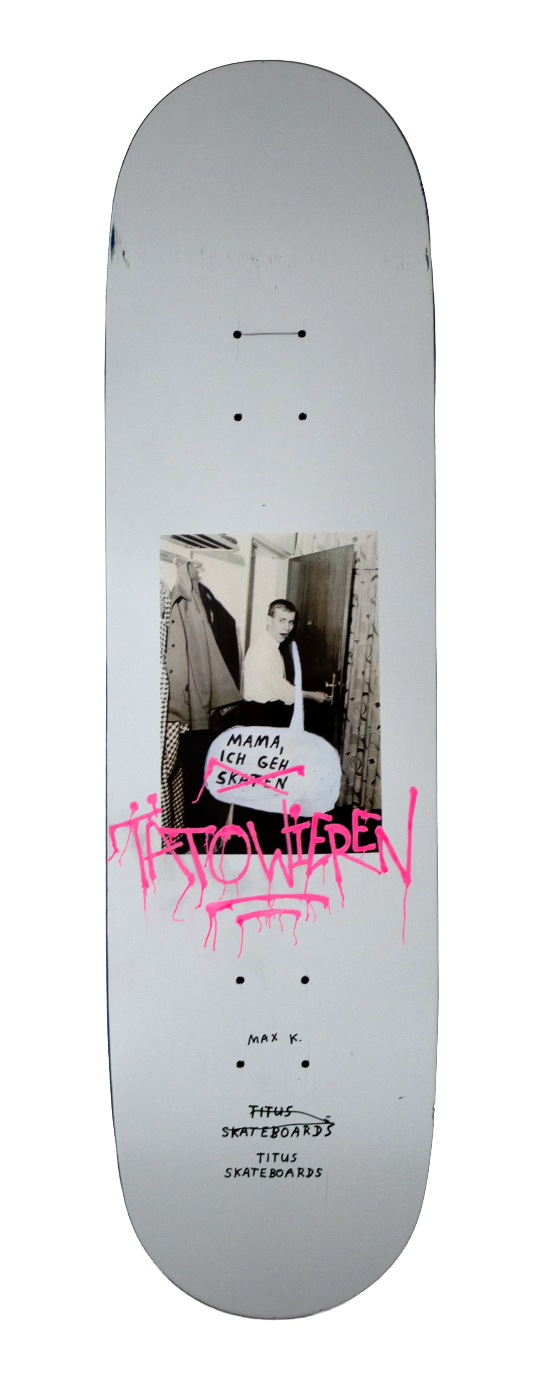 Skateboard mit Graffiti, einem schwarz-weißen Foto eines Jungen mit einem Schild, das sagt 'Mama, ich geh skaten', und pinker Handschrift 'JETZT HÖREN', auf der Unterseite sind verschiedene Skater-Marken und -Namen.