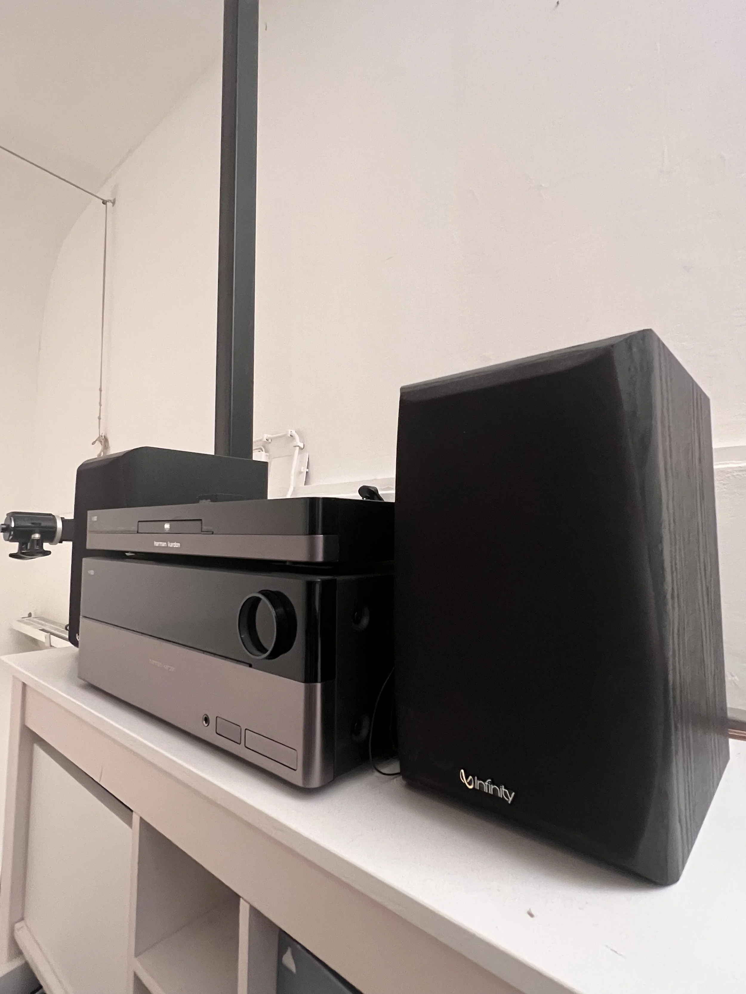 Ein Plattenspieler mit Boxen auf einem weißen Möbelstück.