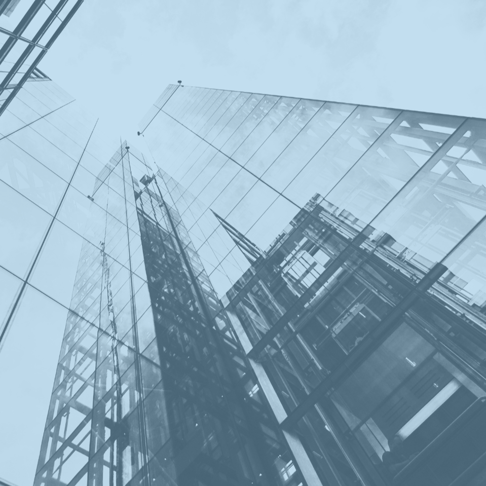 Looking up at modern glass skyscrapers with reflections and steel framework.