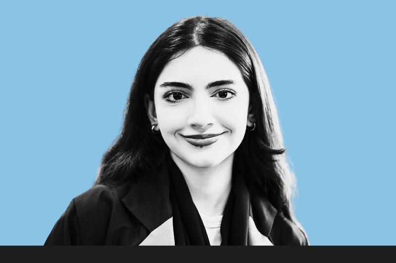 Portrait of smiling young woman on blue background