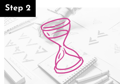Illustration of a pink hourglass with a black label in the top left corner reading "Step 2," on a desk with notebooks, pens, and papers.