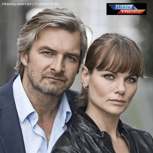 Een man en een vrouw staan dicht bij elkaar, beide kijken serieus naar de camera. Op de achtergrond is een logo van Flikken Maastricht te zien.