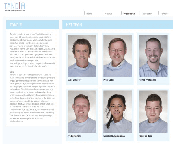 Teamfoto van zes medewerkers van Tandtechnisch Laboratorium Tand'M, waaronder Marc Gimbrère, Peter Spoor, Remco v/d Sanden, Ivo Kerremans, Ghlaine Rumahailel en Pieter de Been, in vakantiestijl met blauwe overhemden.