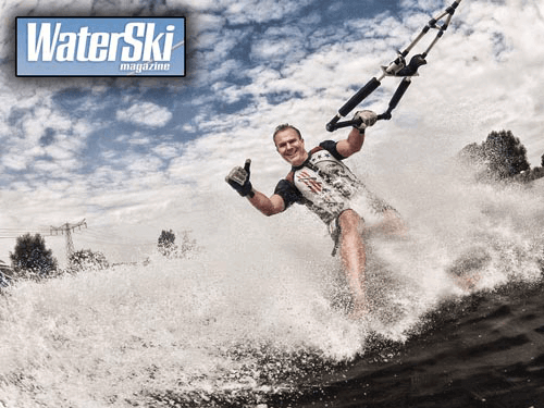 Man die waterskiën terwijl hij een sprong maakt, water spuit omhoog, op de cover van Water Ski magazine.